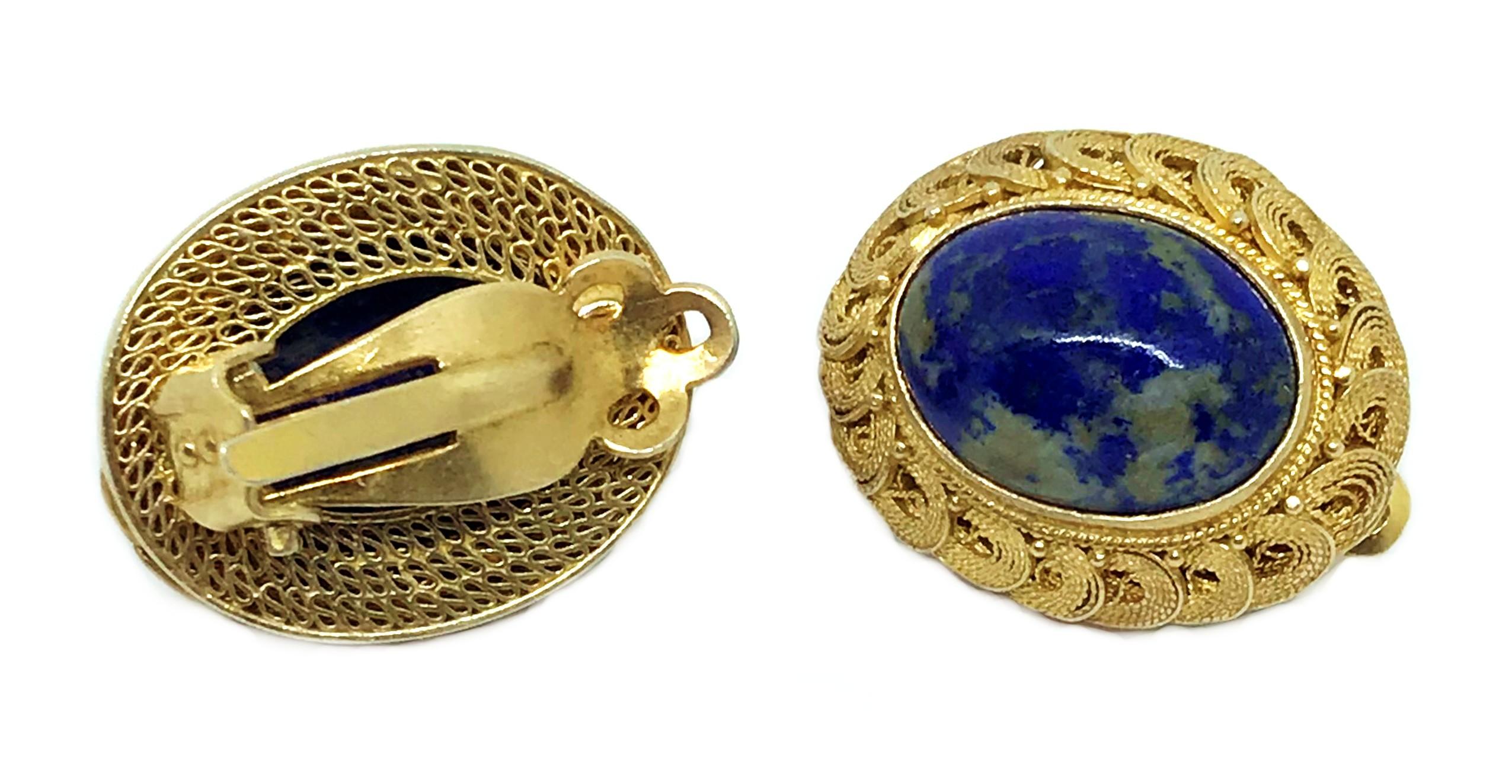 Circa 1950s to 1960s Chinese gold-plated sterling silver clip-back earrings set with oval sodalite cabochons.  They are done in an ornate filigree design and each earring measures 1