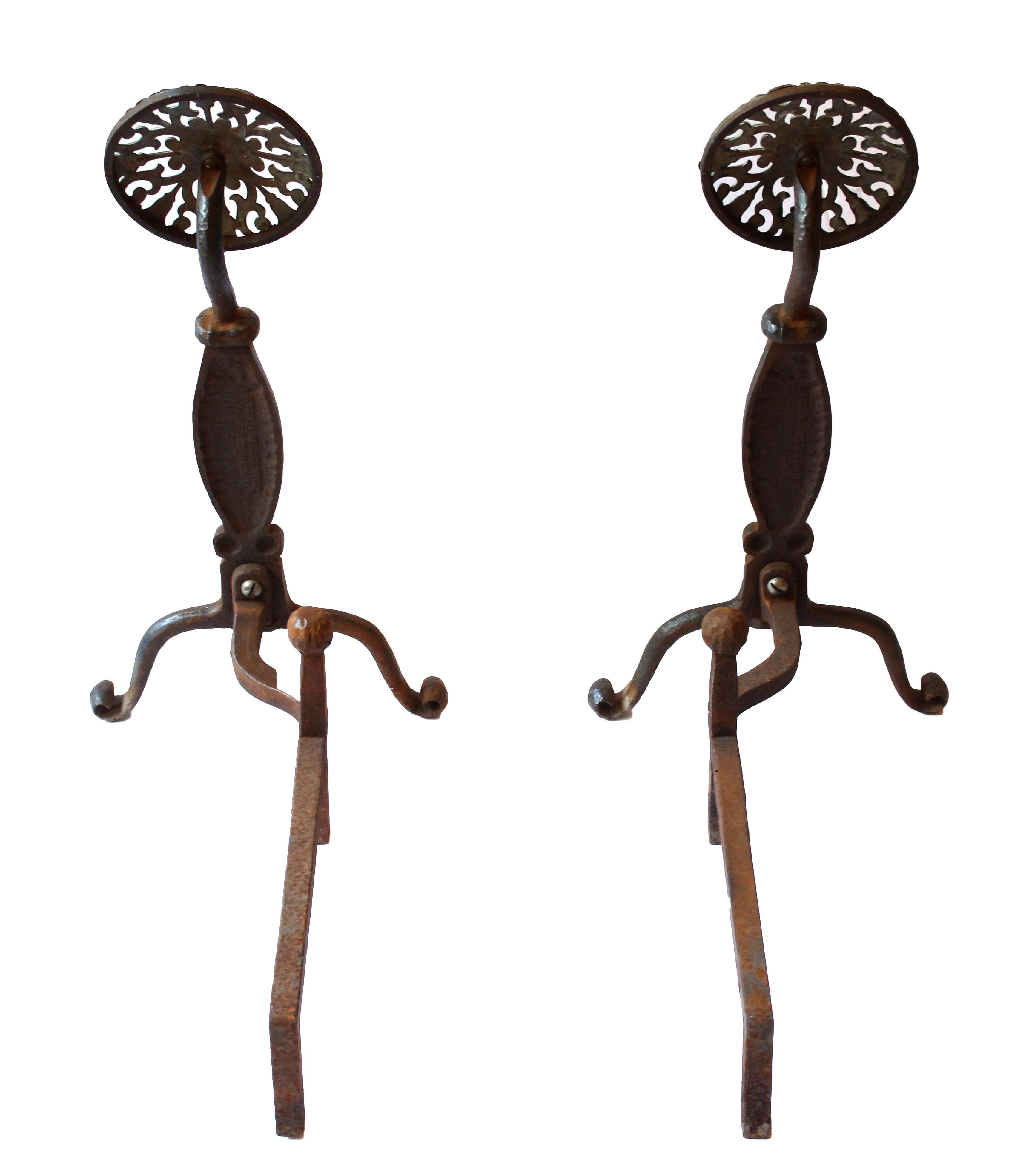 Pair of Iron & Brass Fireplace Andirons by Virginia Metalcrafters, USA, circa 1950s. Italianate design with tulip motif brass panels on forged iron, raised on scrolled feet. Wisp of leaf motif on throat of shafts. Made in their Waynesboro, VA