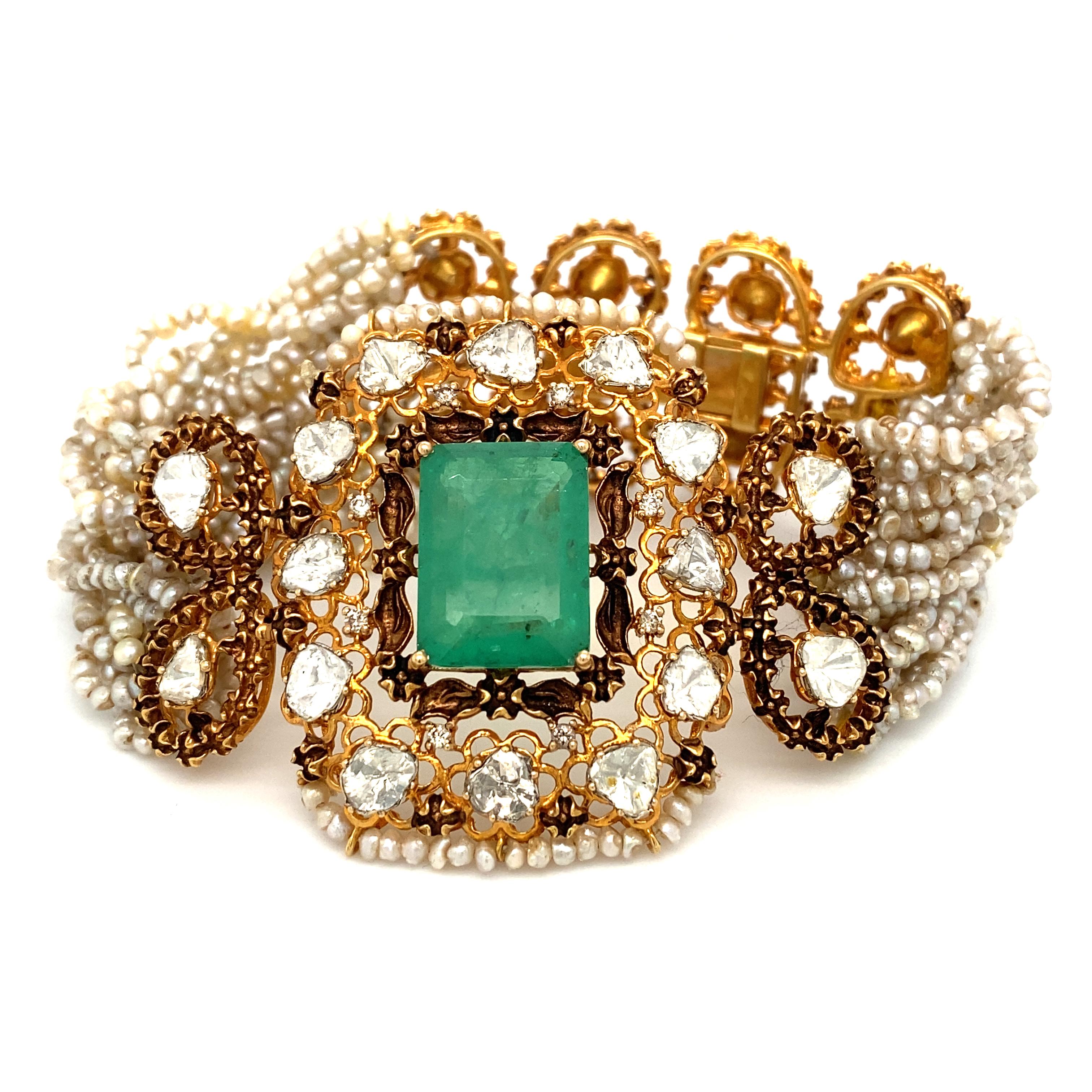 Item Details: This Victorian style bracelet has numerous rice pearl strands, foil backed diamond accents and an emerald doublet in the center section, and is crafted in 14 karat gold. This bracelet is a Victorian revival piece from the 1950s and is