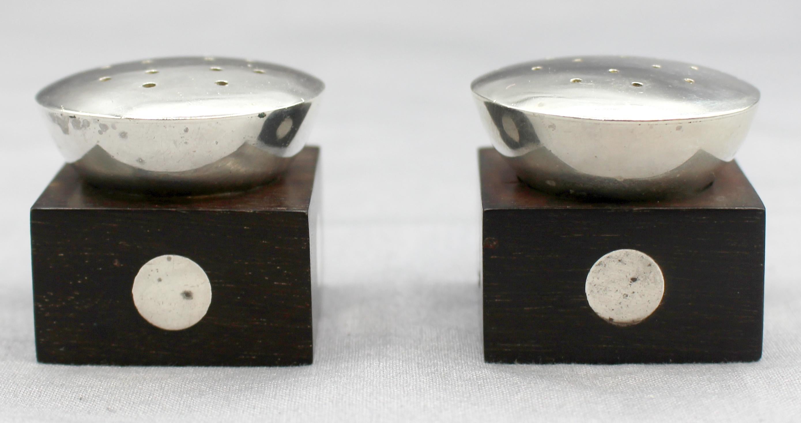 Pareja de saleros y pimenteros de plata de ley y madera de William Spratling de hacia la década de 1950. Incrustaciones de disco de firma de plata de ley en los fondos. Cubos con incrustaciones de discos de esterlina y tapas de esterlina. Disco de