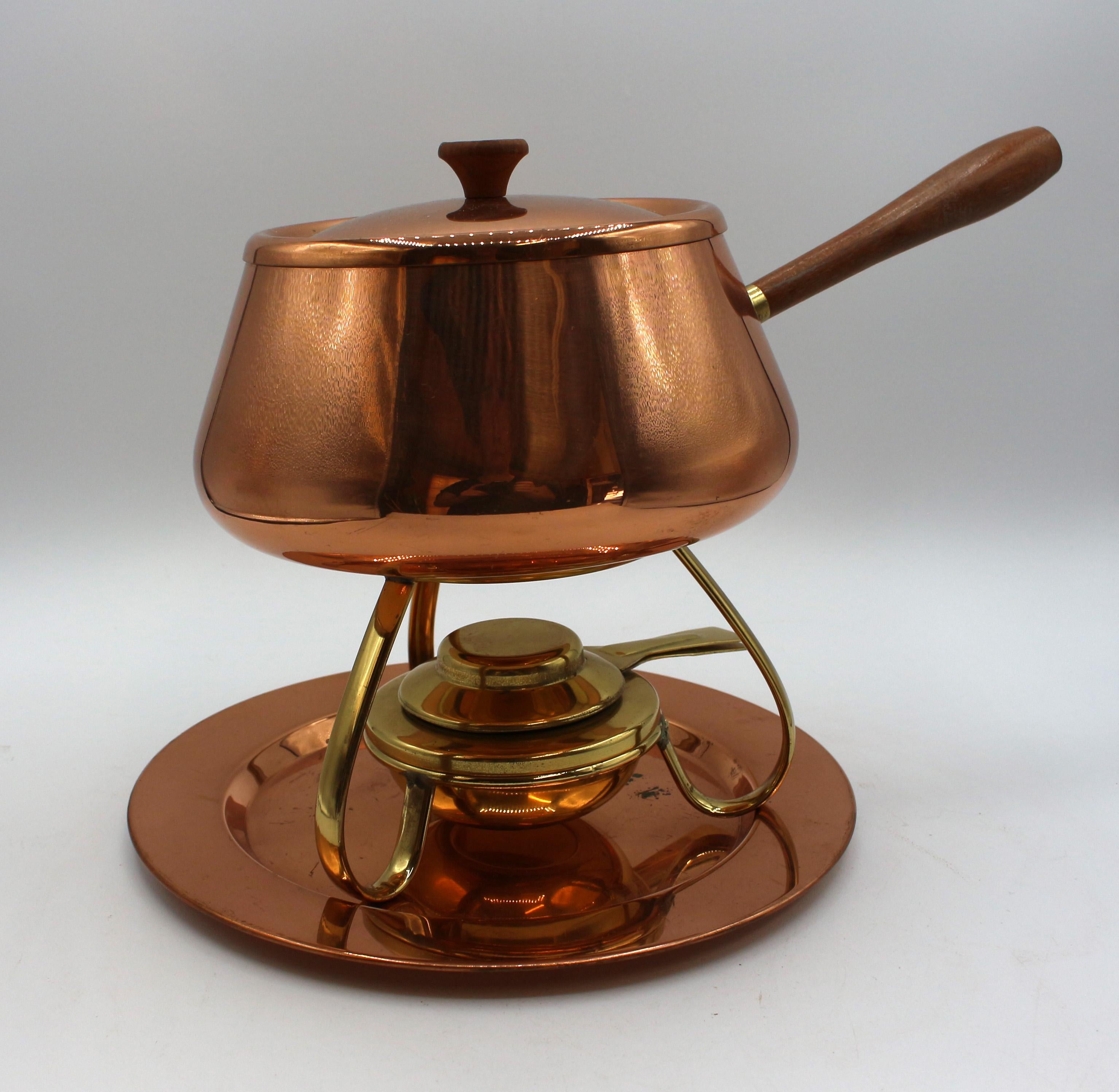 Circa 1960s copper fondue pot & stand by Magellan made in Portugal. Solid copper, tin lined with teak handle & finial. Stand of solid brass sits on the copper tray. With original care instructions. Stamped 