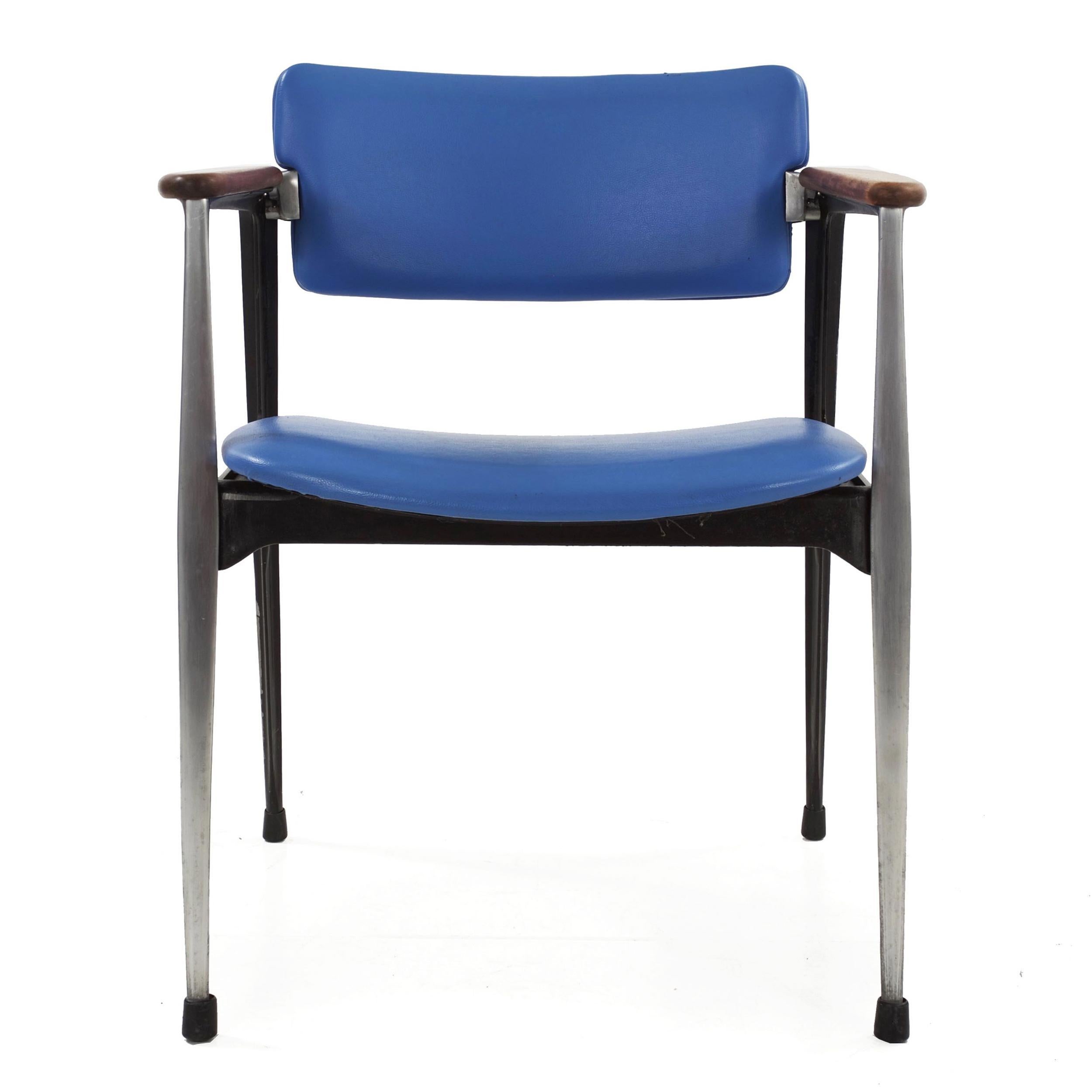 Built to last an eternity, this cast aluminum chair was designed by Dan Johnson for Shelby Williams and still retains the original manufacturer tag from Crucible Products. It retains the original light blue leatherette, which though worn still