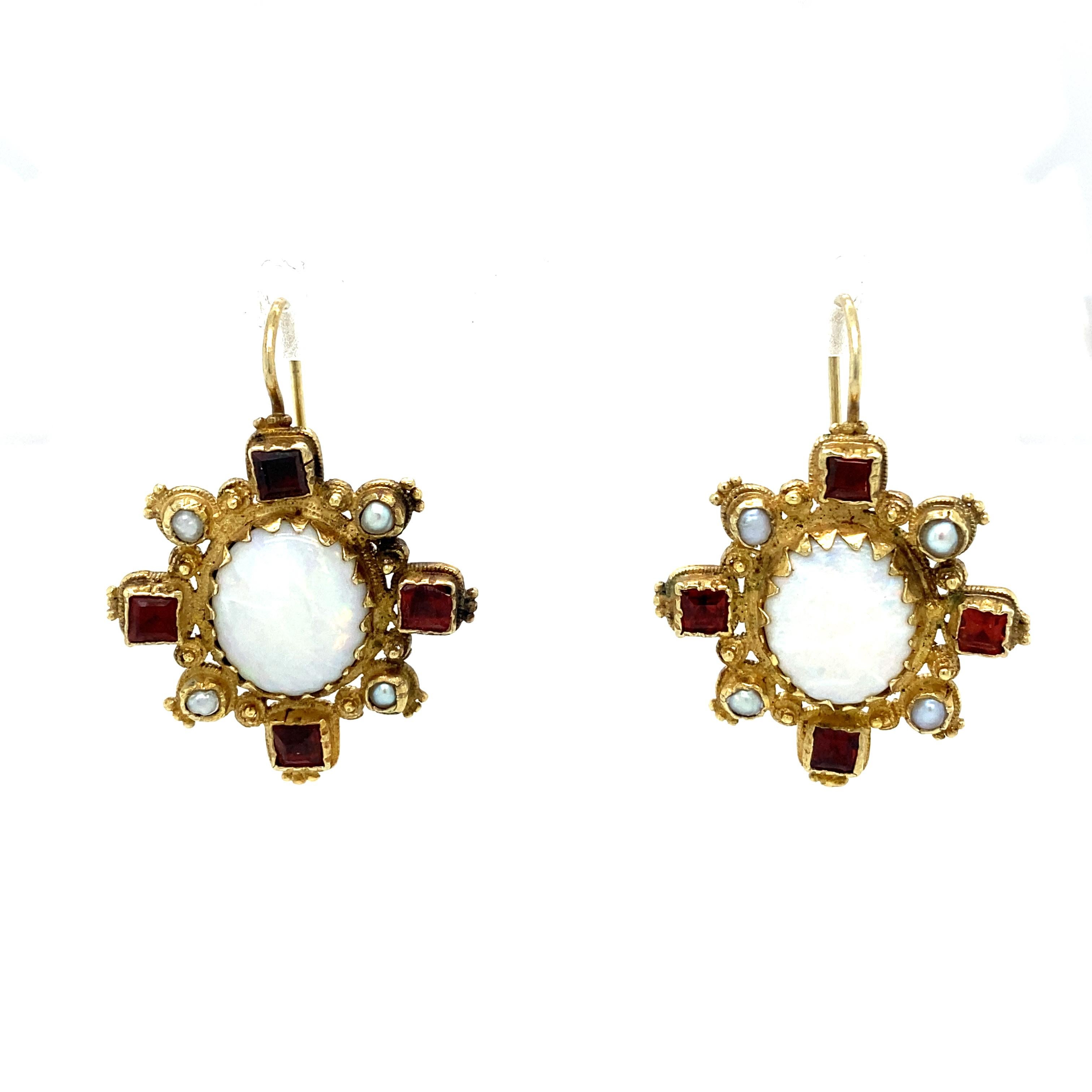 Item Details: These Renaissance-style earrings have opals, pearls and square cut garnets in an ornate 14k gold setting.

Circa: 1960s
Metal Type: 14 Karat Gold
Weight: 9.8 grams
Size: 1.25 inch Length 