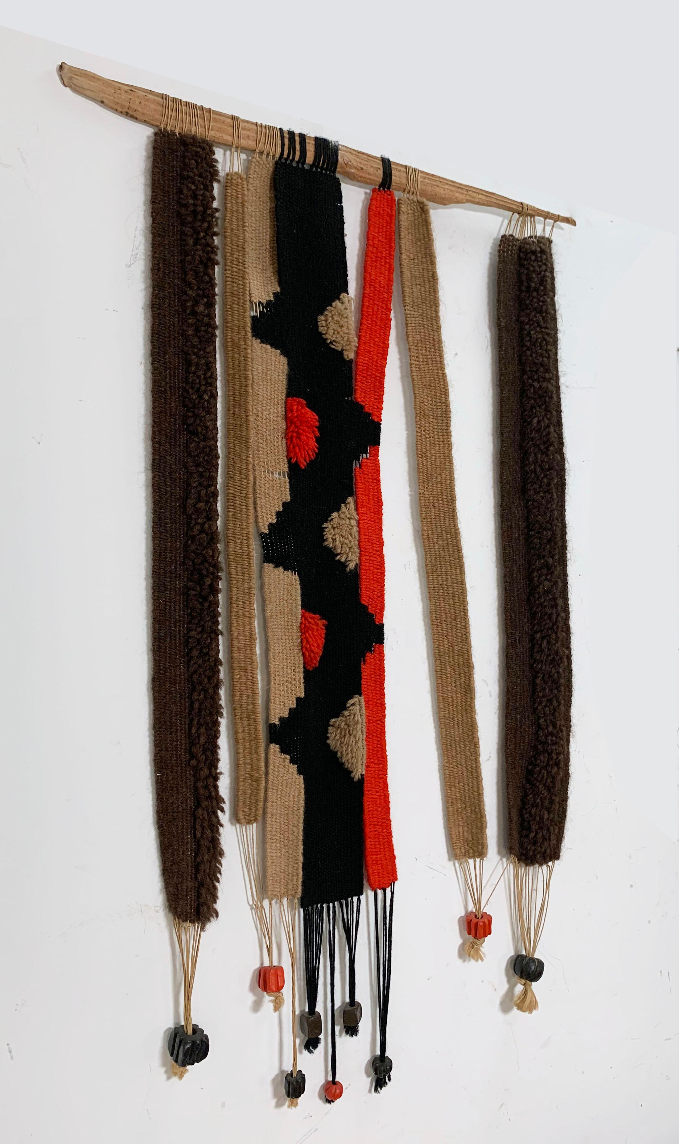 Artist made woven wall hanging of attached panels with oversized ceramic beads on a driftwood hanger, circa 1960s. Artist unknown, although signed with initials.