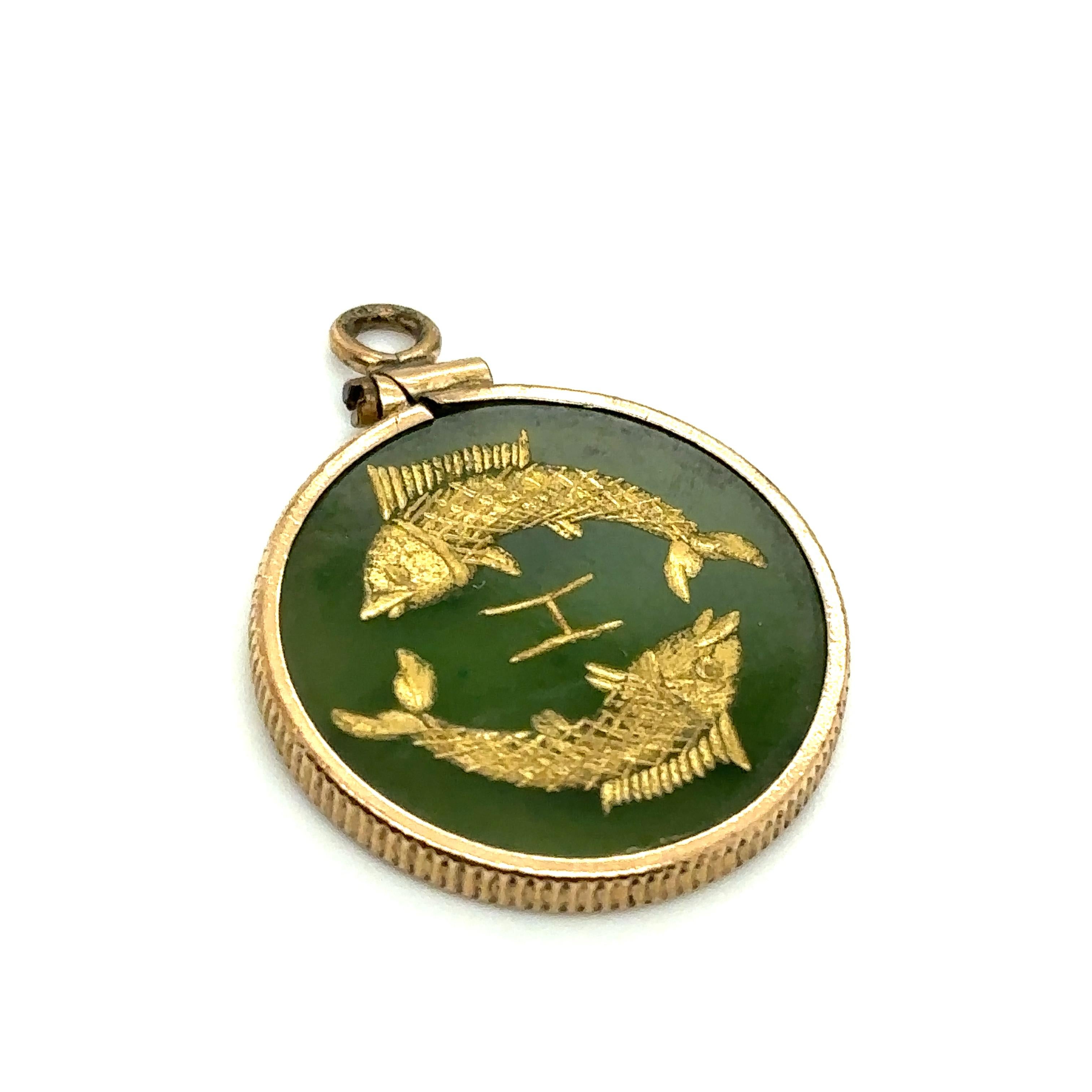 Item Details: This 1960s Pisces fish zodiac pendant is made of 10k gold with a green glass disc and an intaglio style design. 

Circa: 1960s
Metal Type: 10 Karat Yellow Gold
Weight: 2.7 grams
Size: 1 inch diameter