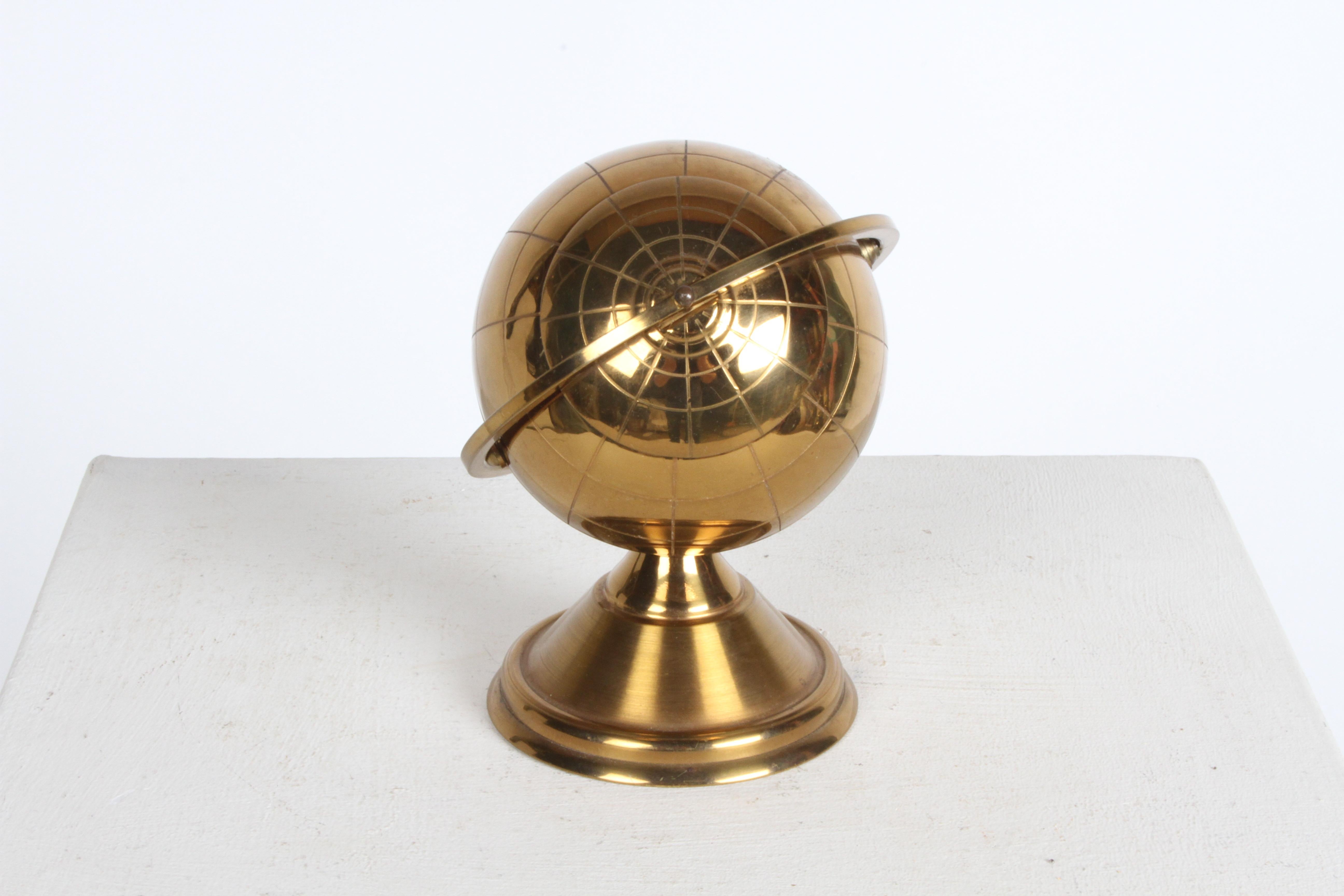 Mid-century Modern Sputnik era, brass globe cigarette holder. The lid slides open on the globe's axis to reveal an interior enamel metal compartment designed to hold cigarettes or whatever. Nice clean bright brass, some wear to interior enamel. 

