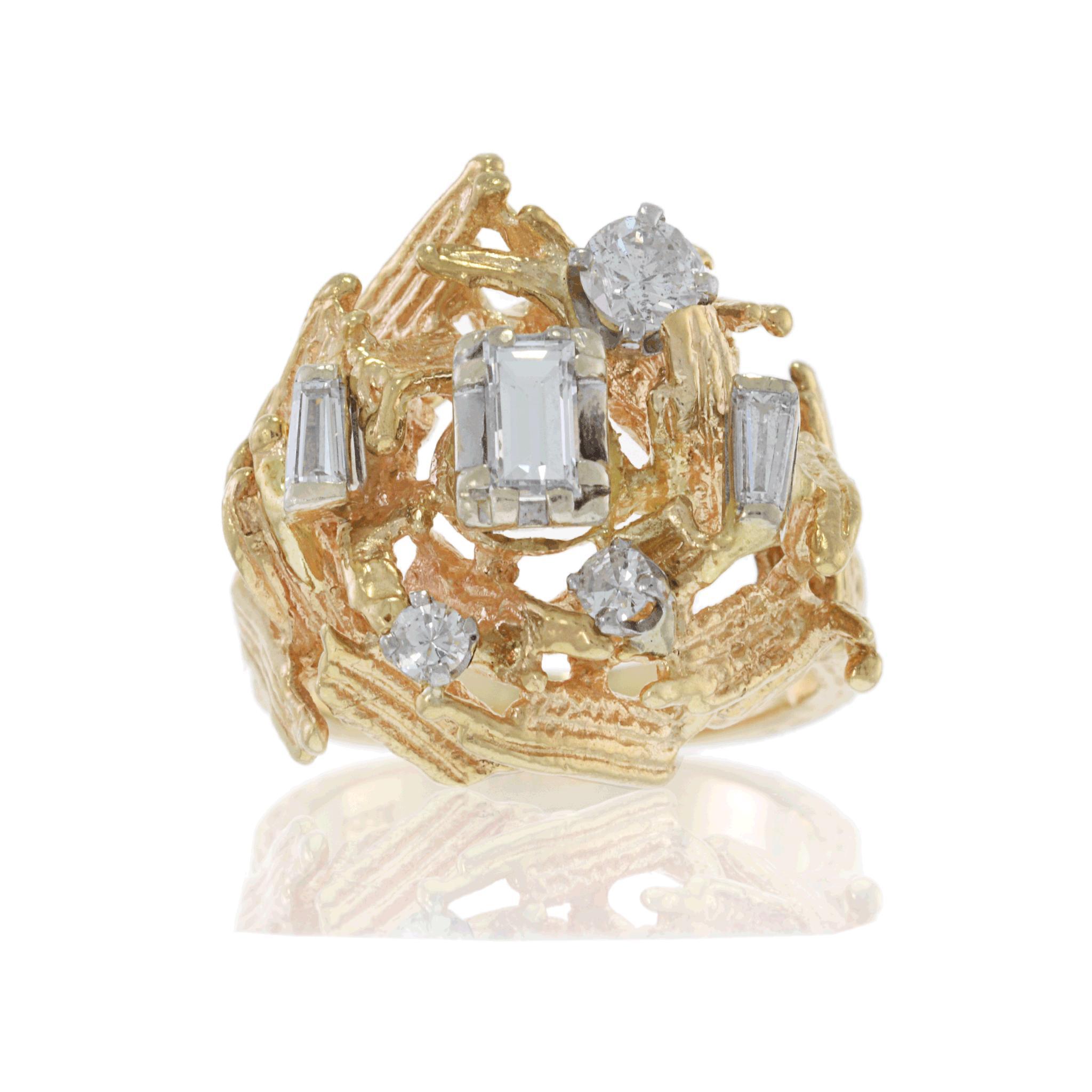Cette bague exquise datant de 1970 est fabriquée en or jaune 14KT et présente un diamant central sophistiqué de taille émeraude entouré d'un arrangement unique de diamants baguettes et ronds, pour un total de 0,70CT-TW. La monture en or texturé