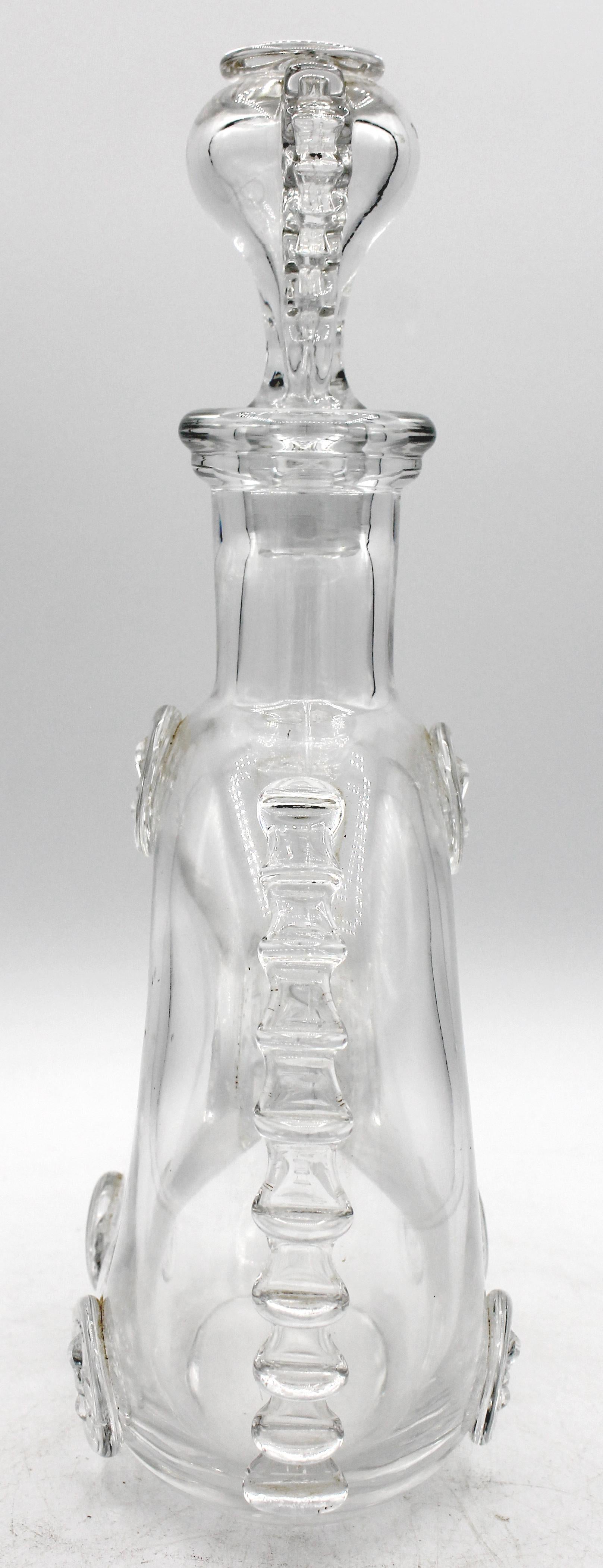 Decantador y tapón de cristal para coñac Remy Martin Louis XIII de Baccarat, años 70-80. Botella de cristal soplado con volantes aplicados a mano en los hombros y medallones de flor de lis en el cuerpo y el tapón. Buen estado. Marcas grabadas al