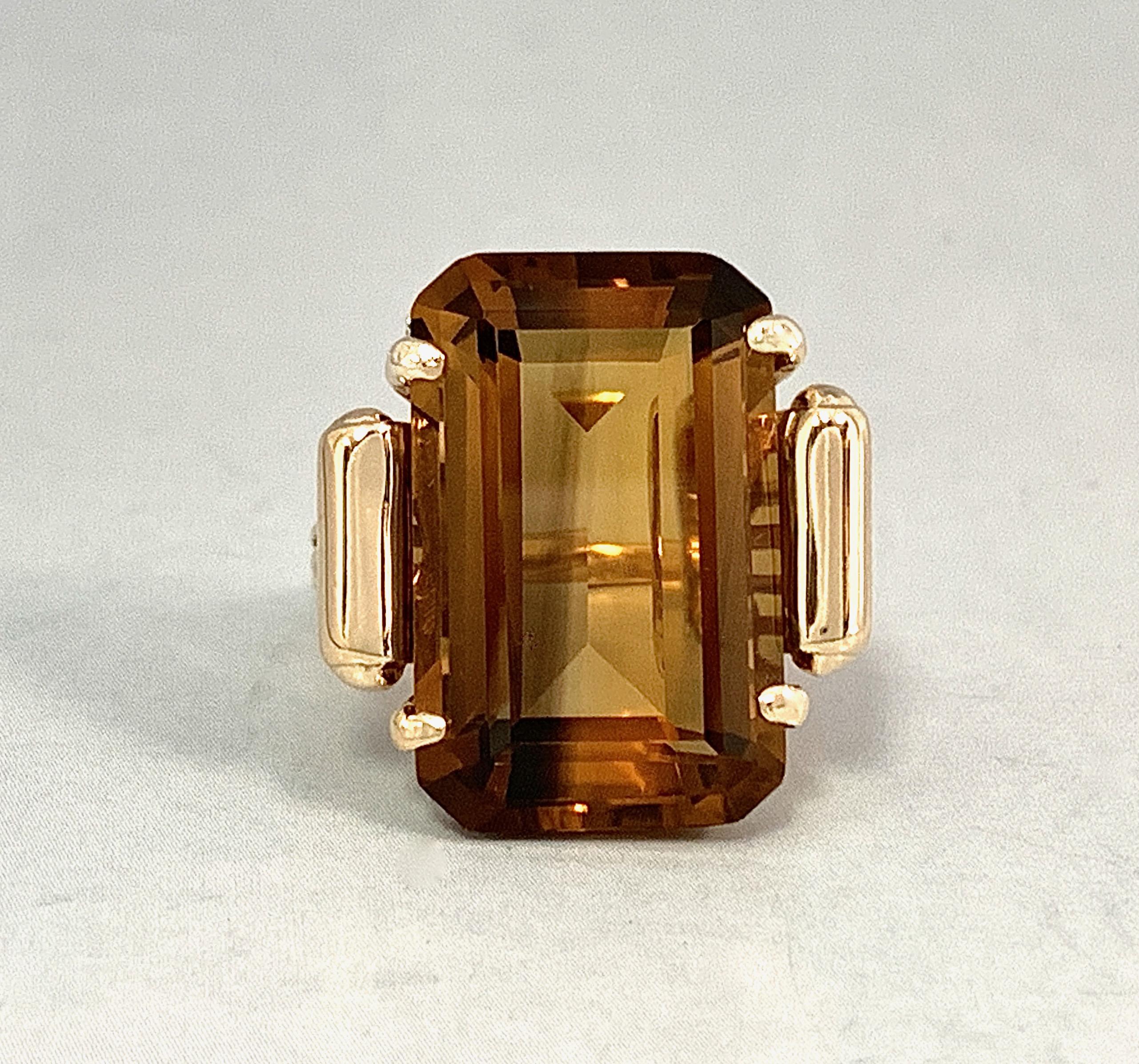 This classic 1970's cocktail ring features a gorgeous, clean and newly polished quartz, emerald cut and in an extremely unusual shade of golden honey-brown.  It probably would have been sold as a smoky quartz as that was an extremely popular stone