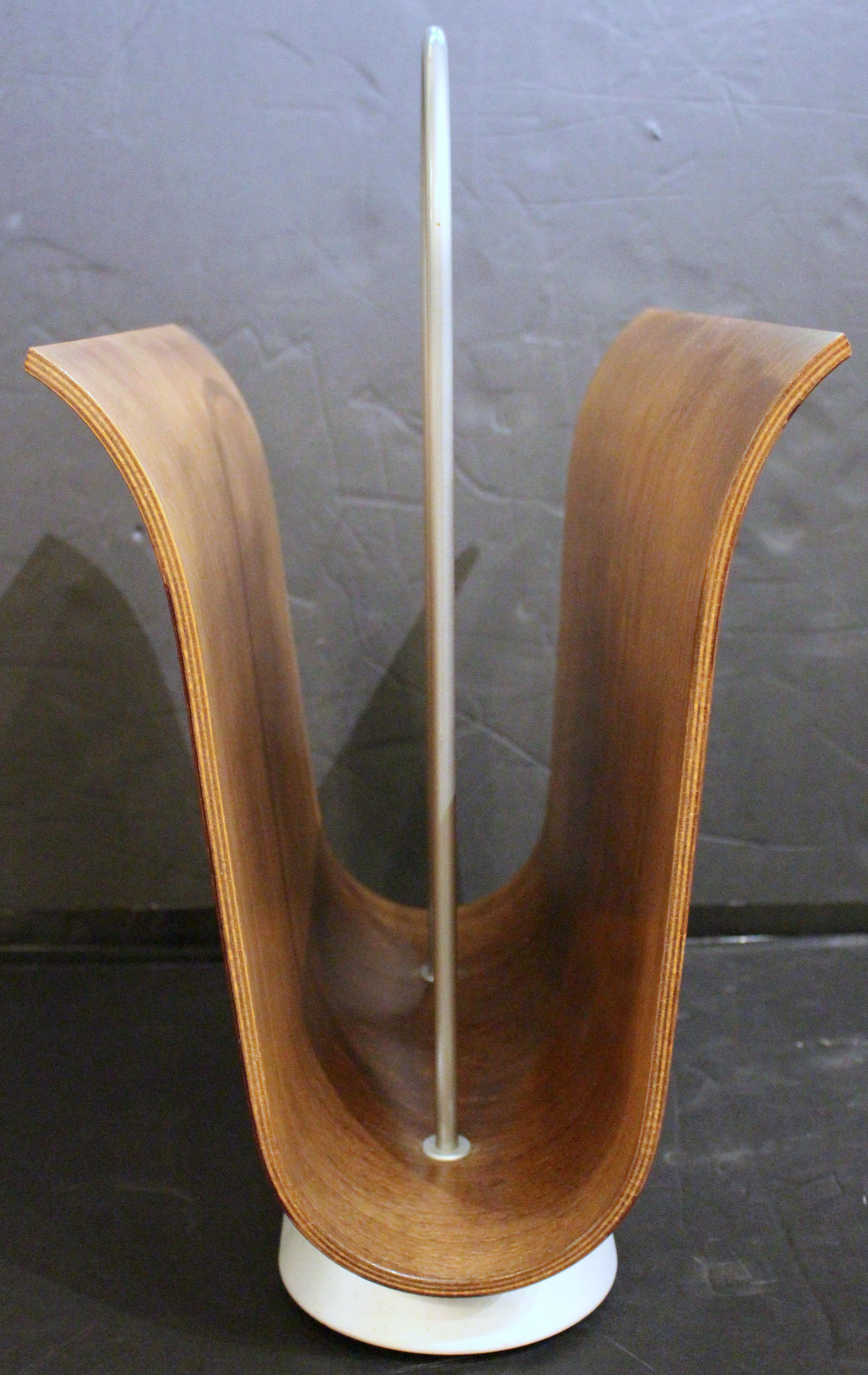 Circa 1970 magazine rack by Ligne Roset, France. Sculptural U-shaped form. Bent laminated wood for remarkable strength. Frosted silver finish on metal handle & base.
15.75