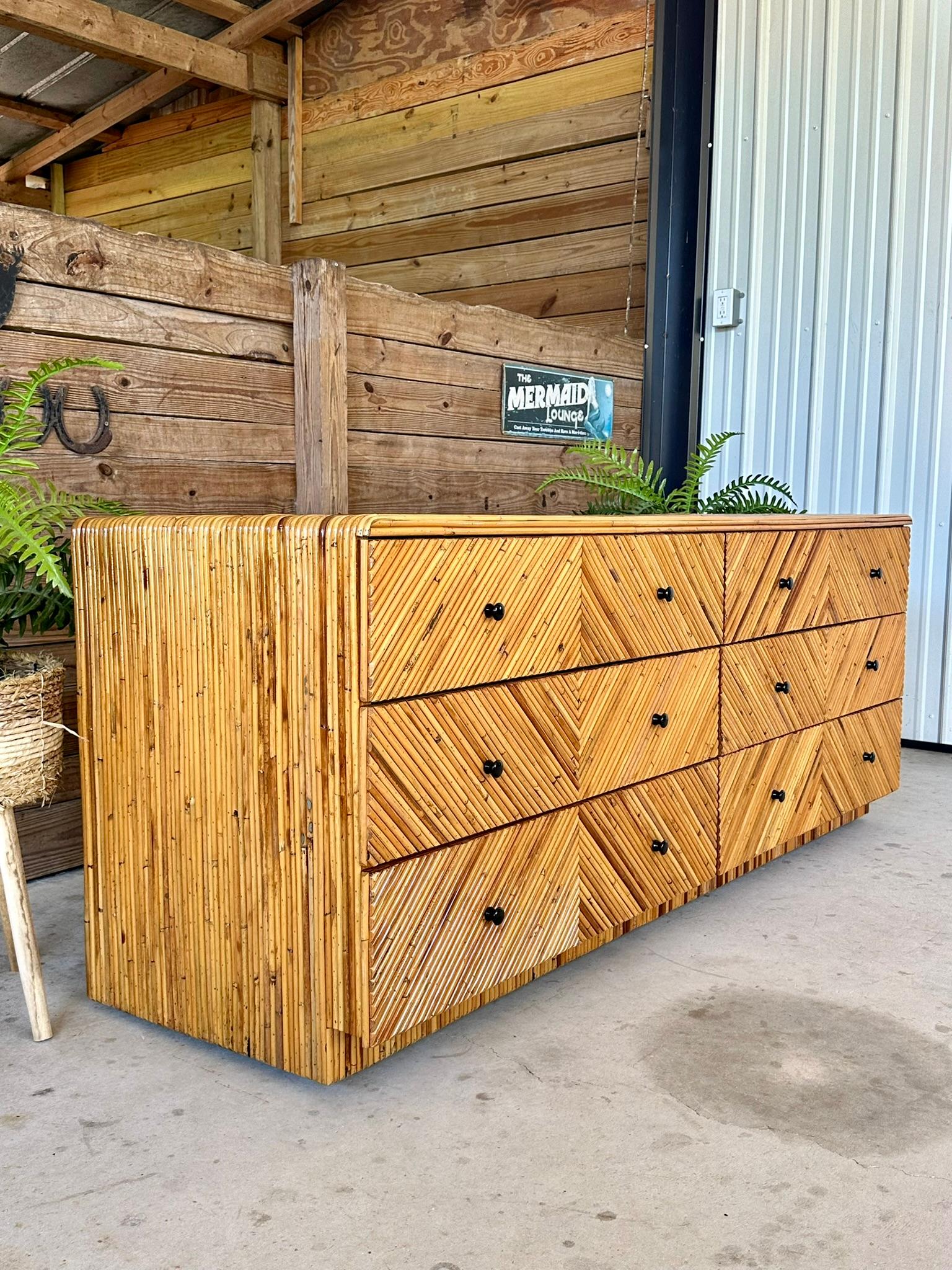 Excellent restored rattan marquetry sideboard/dresser with black lacquer knobs in a sleek waterfall edge design.  Diagonally applied pencil reed rattan forming a diamond pattern on a raised rattan inset base with trim on the backside.  Exceptional