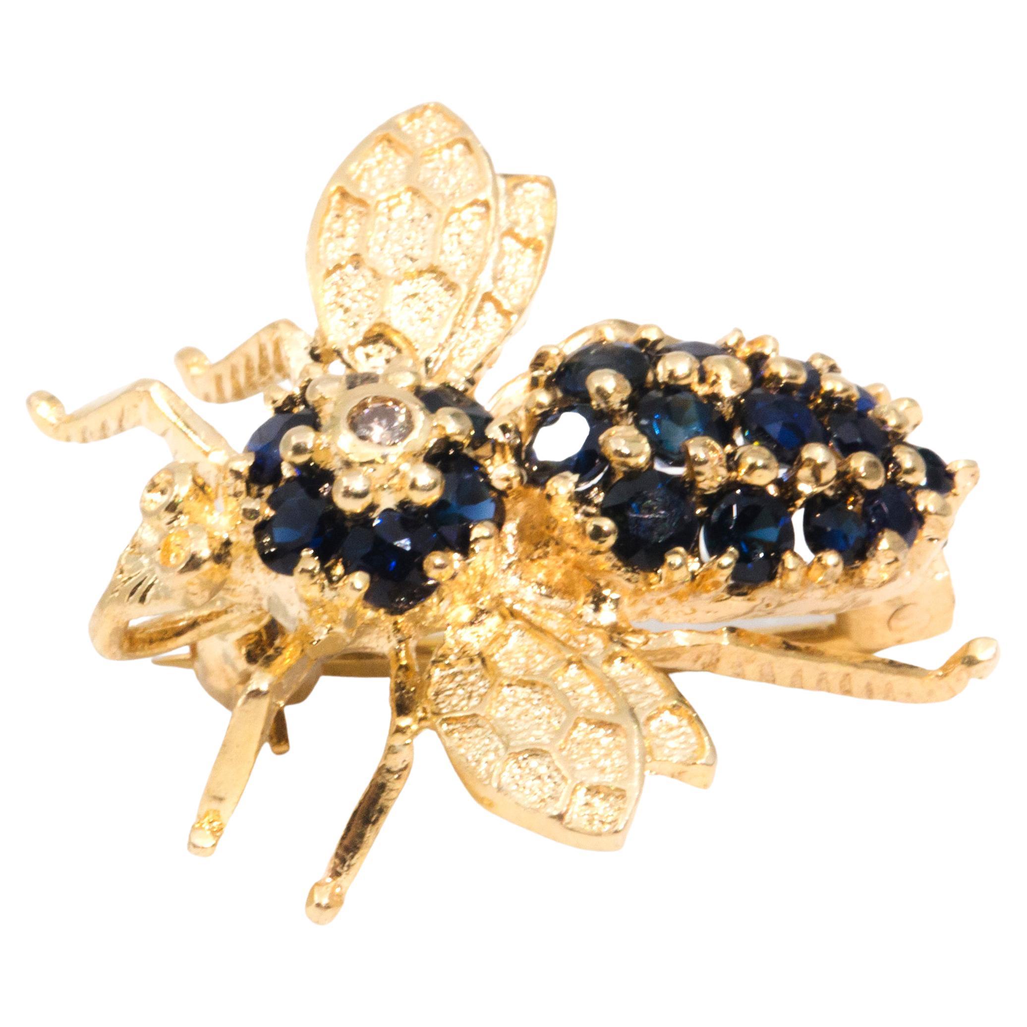 Crafted in 14 carat yellow gold, this whimsical vintage bee brooches is carefully embellished with a single sparkling round brilliant cut diamonds and alluring deep blue sapphires. She is finished with a brooch pin and roller catch. This truly