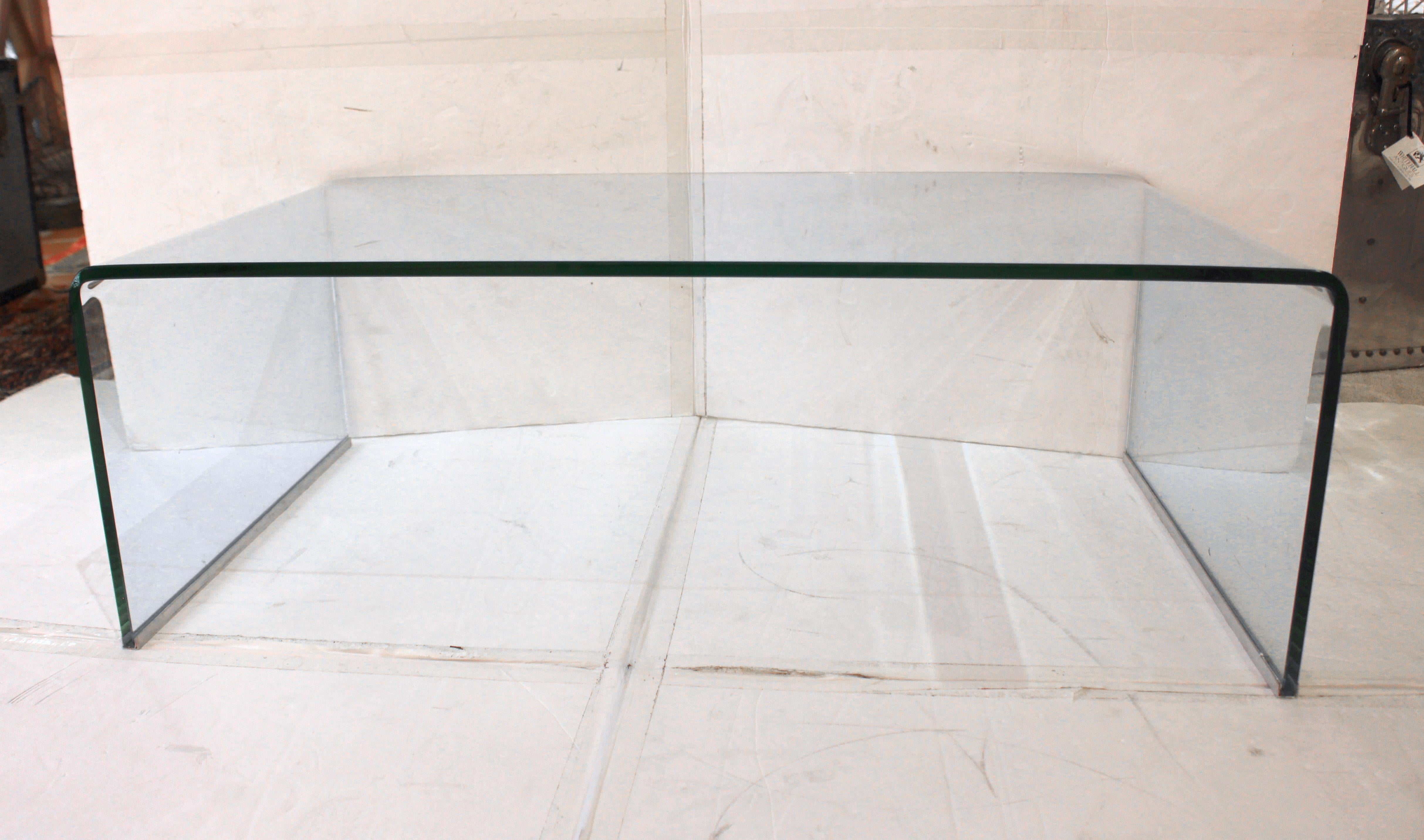 Circa 1970s-1980s waterfall form glass coffee table, European, likely Italian. Mid century modern sleek & elegant design. High quality 1/2