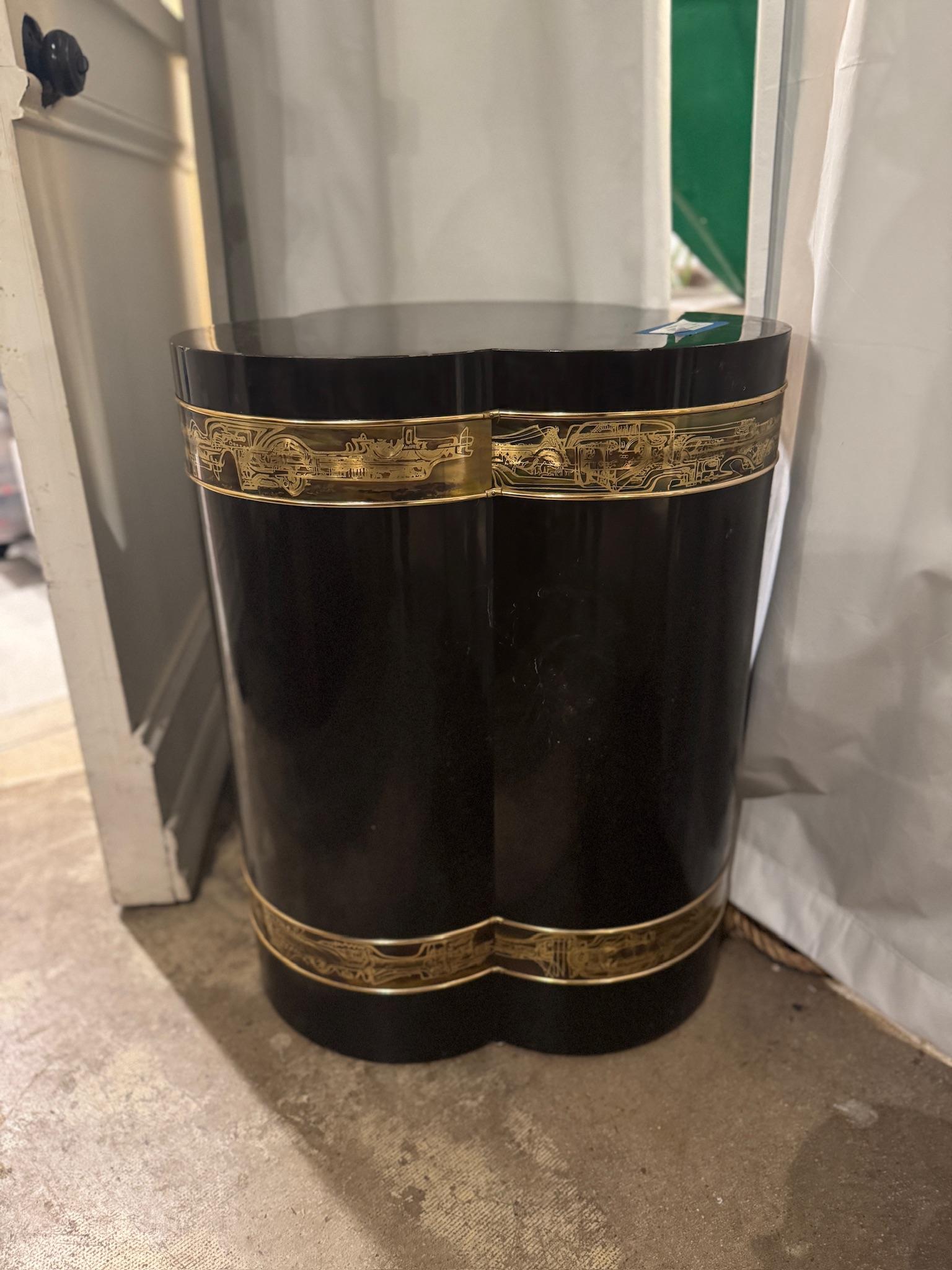 Rara mesa con pedestal trilobulado de Bernhard Rohne para Mastercraft, de la década de 1970, con un lujoso acabado lacado en negro y el característico grabado de latón oxidado. Esta pieza escultórica ejemplifica la opulencia y la artesanía de los