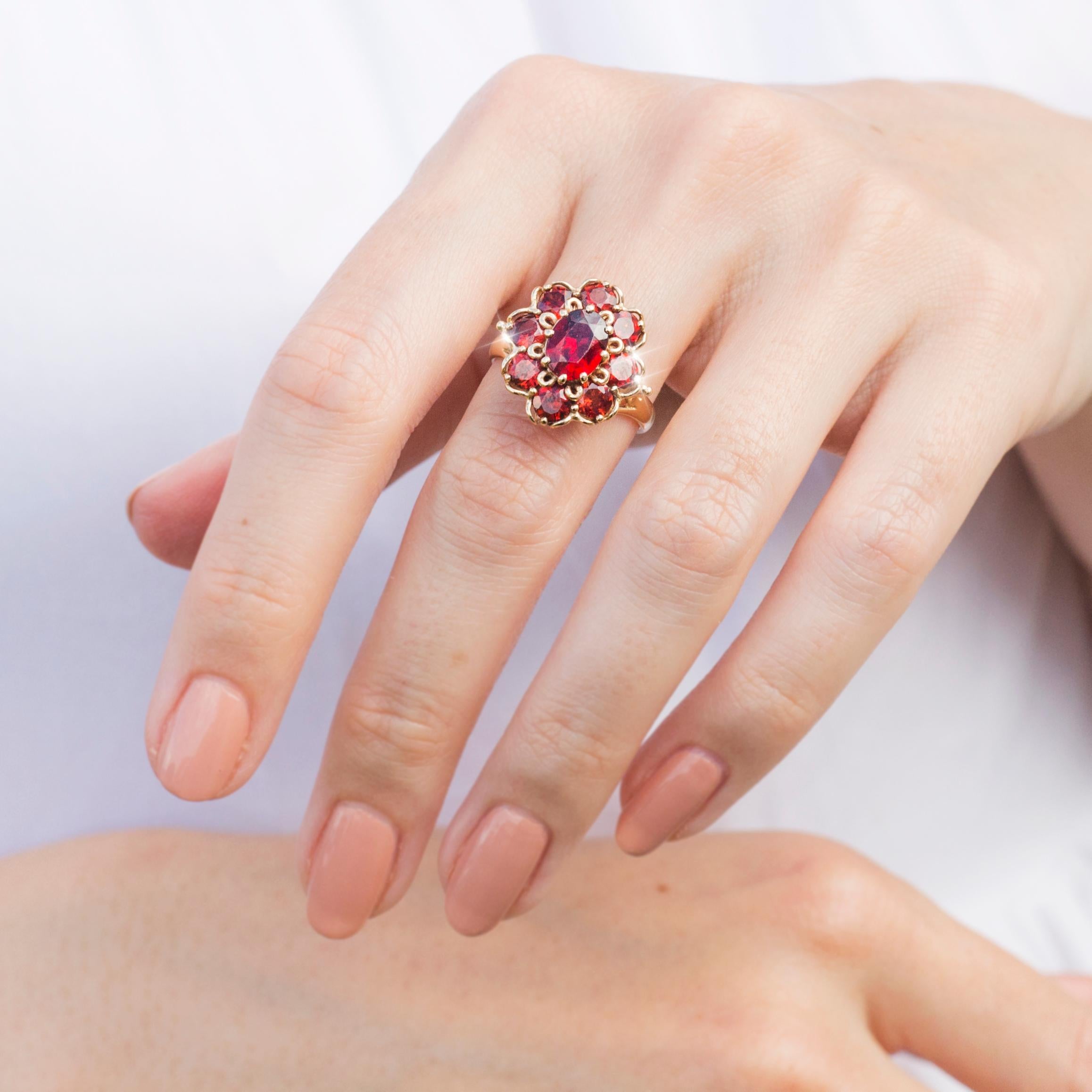 Crafted in 9 carat yellow gold, this gorgeous vintage cluster ring features a fine band raising up a flower gallery carefully set with luminous red garnets. We have named this delightful piece The Marley Ring. Her alluring red hues make her the