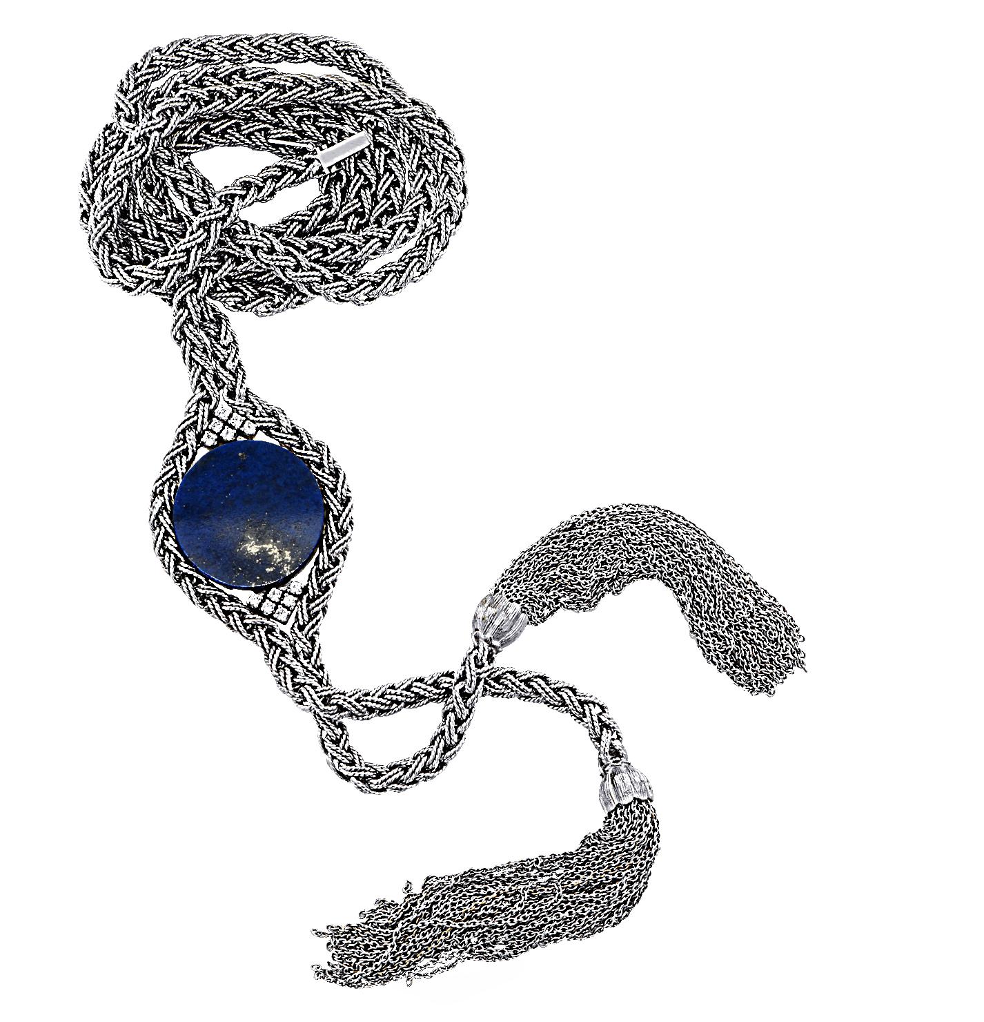 Stunning sautoir necklace circa 1970, crafted in 18 karat white gold, featuring a lapis disc measuring 0.95 inches in diameter, accented by 12 round brilliant cut diamonds weighing approximately 0.30 carats total, G color, Vs clarity. The rope chain
