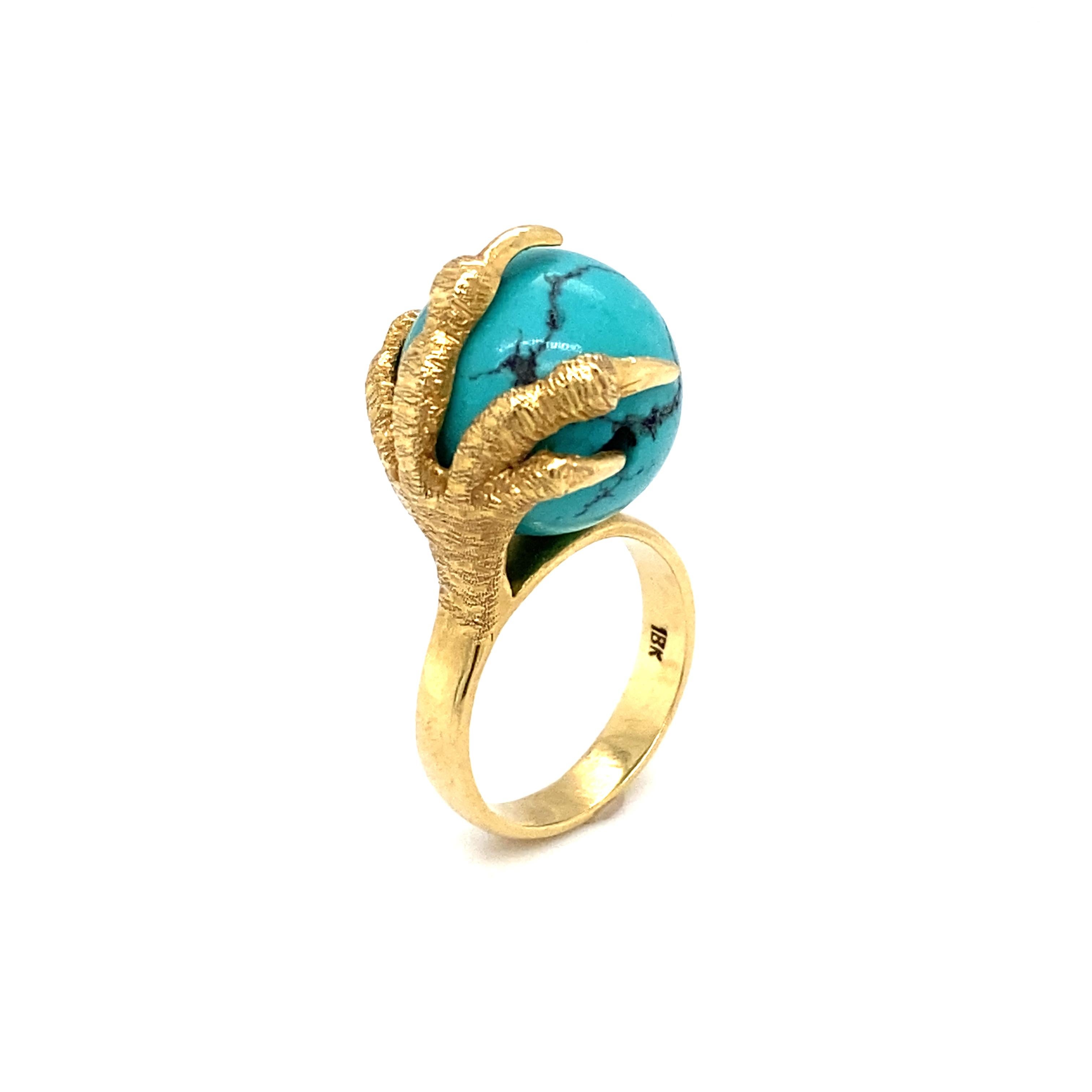 Here we have a stunning ring from the 1970s featuring a beautiful, rather ornate, turquoise, held by talon prongs, seemingly belonging to a bird of some sort. The claw talons are very heavily detailed. They are crafted in 18 Karat Yellow Gold, and