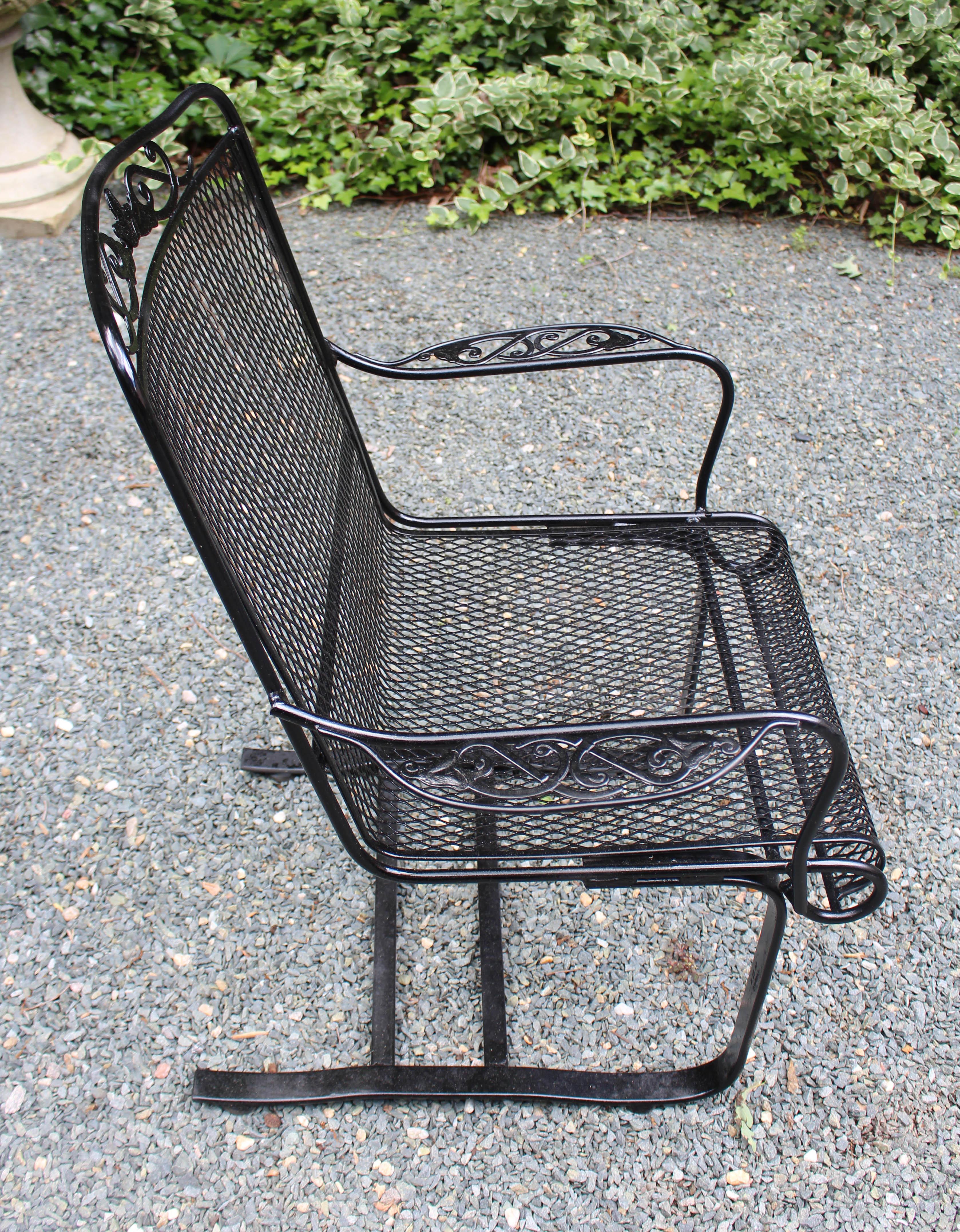 Circa 1970s wrought iron spring arm chair, attributed to Russell Woodard. Sometimes called a bouncer, it is a very popular form! Leaf & scroll motif on crest & arms. Repainted.
26 7/8
