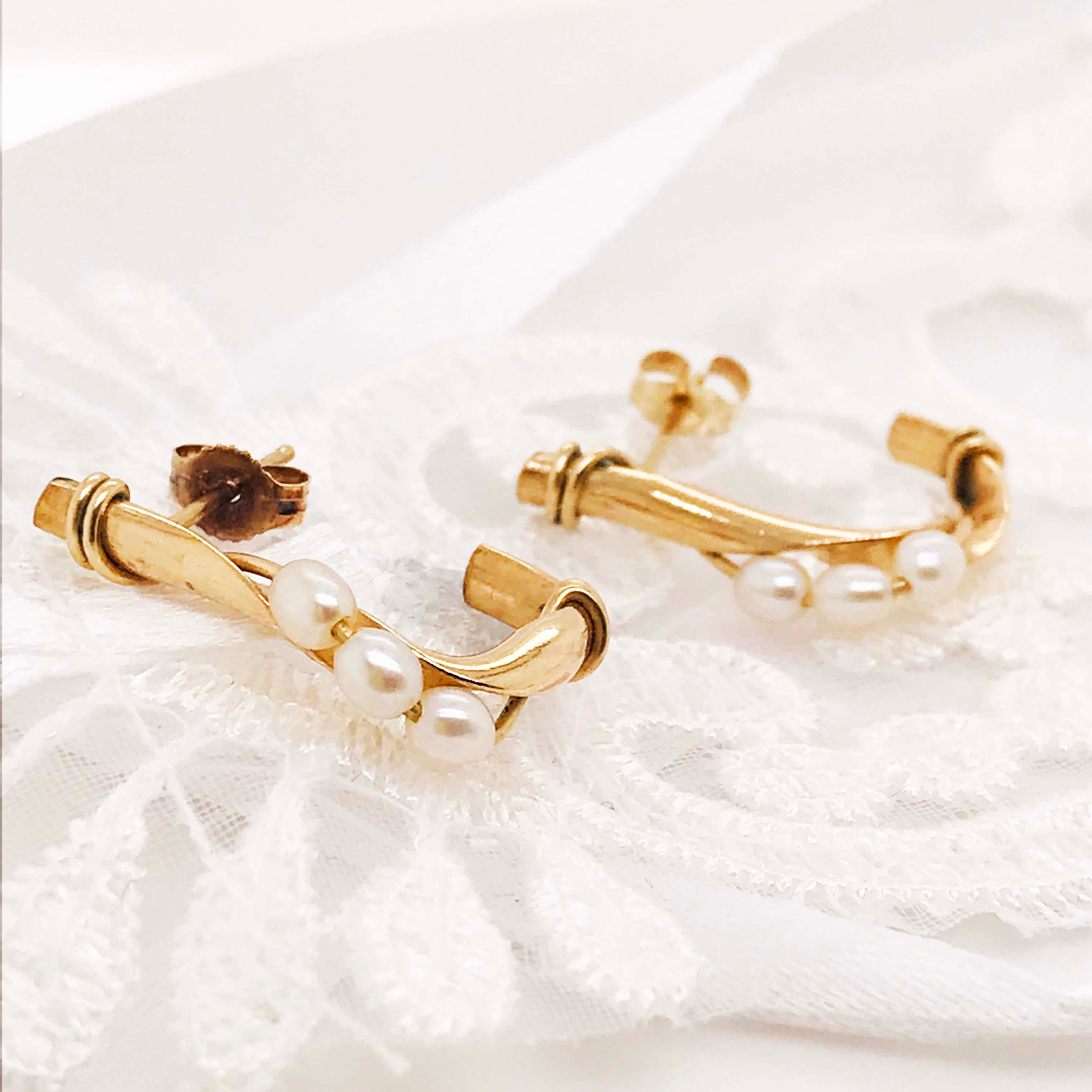 The sweet, traditional pearl earrings have a unique J form and design. With three genuine pearls strung on a gold wire and set on a custom J shaped earring. The pearl earrings have a 14k yellow gold twisted, bark-like design that looks like natural