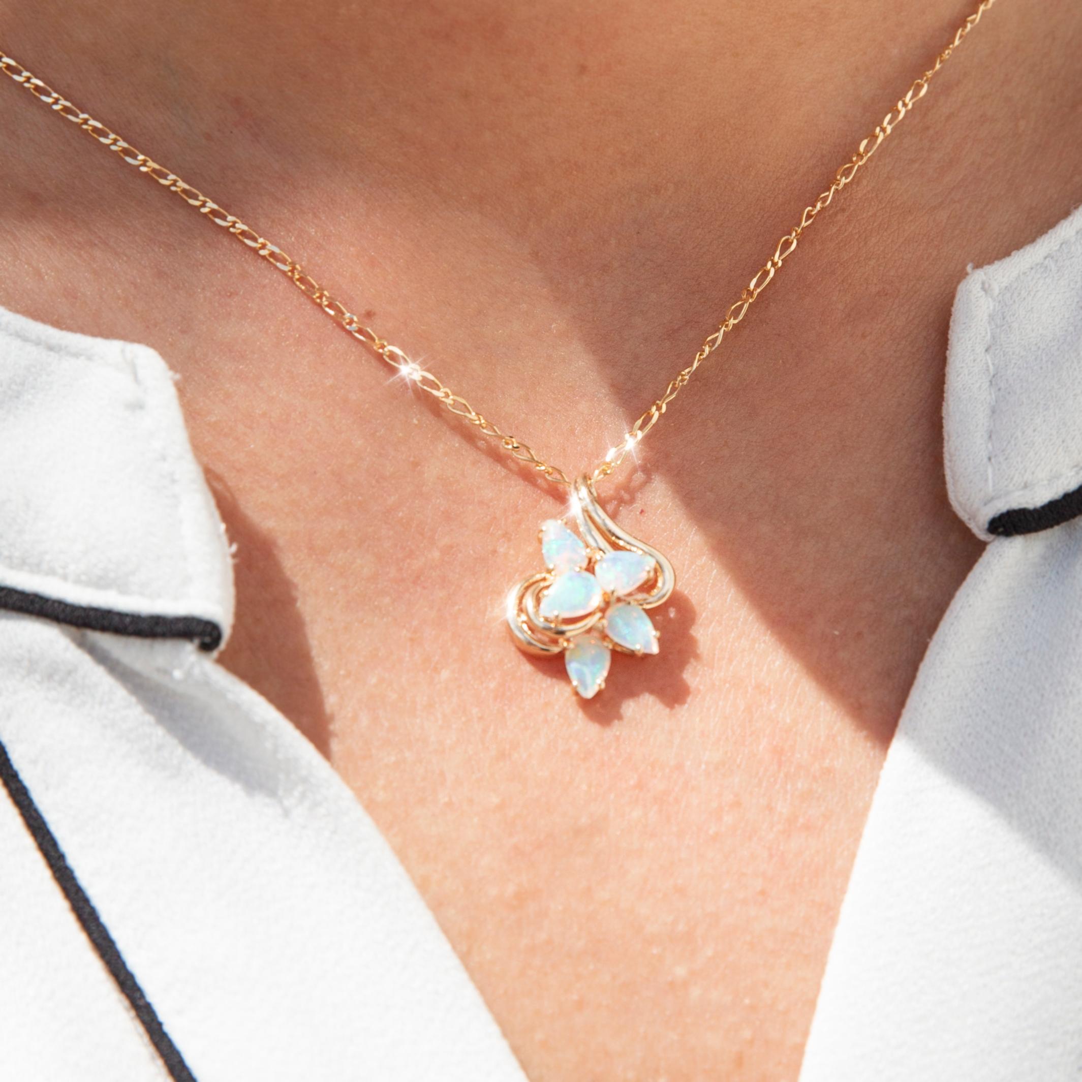 Réalisé avec soin en or jaune 9 carats, ce séduisant pendentif vintage présente cinq magnifiques opales en cristal bleu-vert en forme de poire, disposées en une formation de fleurs torsadées sur un cadre élégamment incurvé. Le pendentif est enfilé