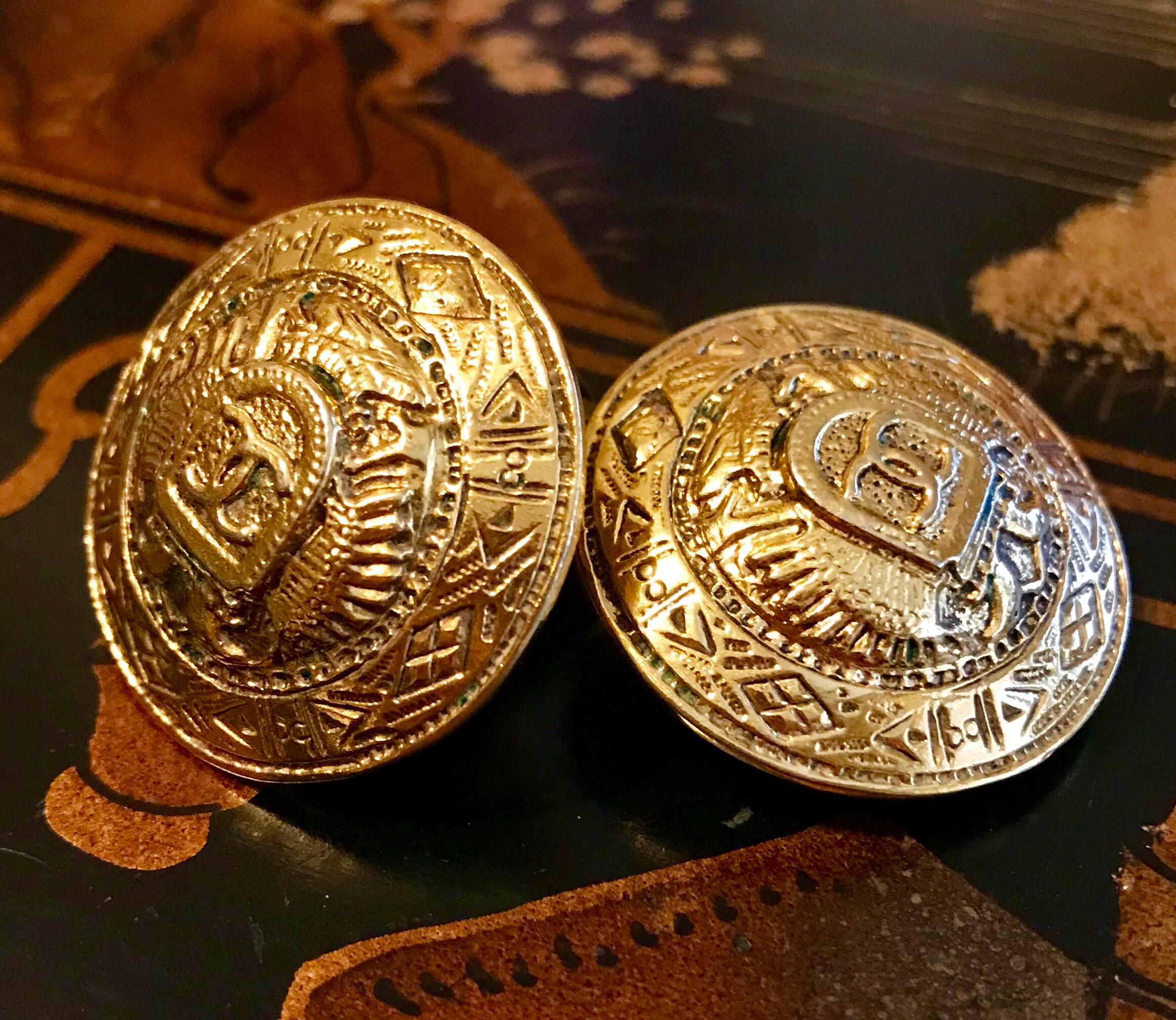 Circa 1980s Chanel round goldtone metal clip back earrings embellished with shields and eagles.  Each earring measures 1.13