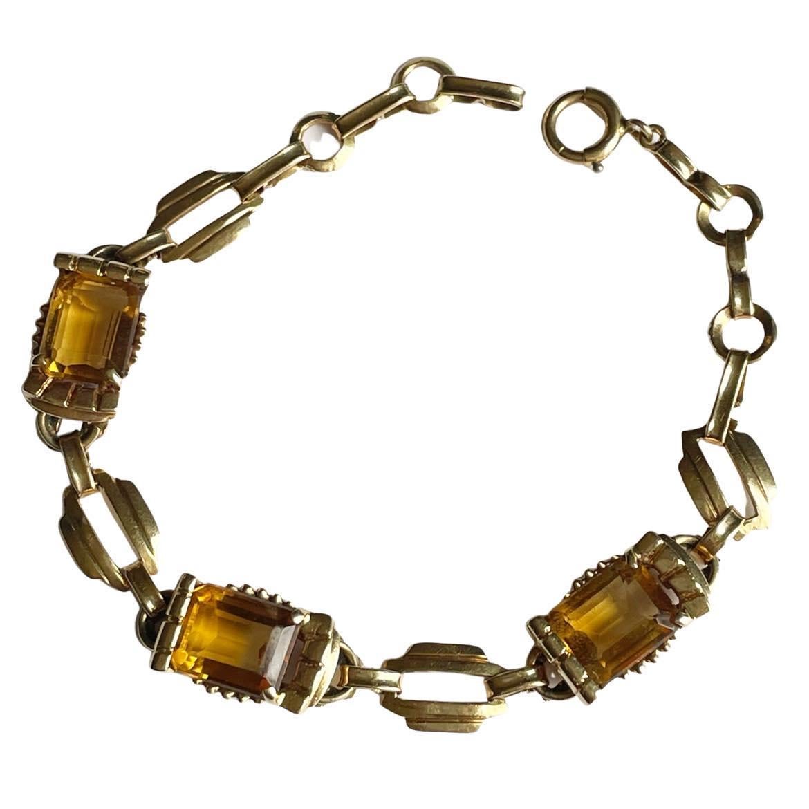 Here we have a beautiful retro link style bracelet. Crafted in 14K yellow gold, the link design is a flatten chain style. Minimal is engraving to not take away from the show piece that is the emerald cut citrine gems. The prong setting is bold,