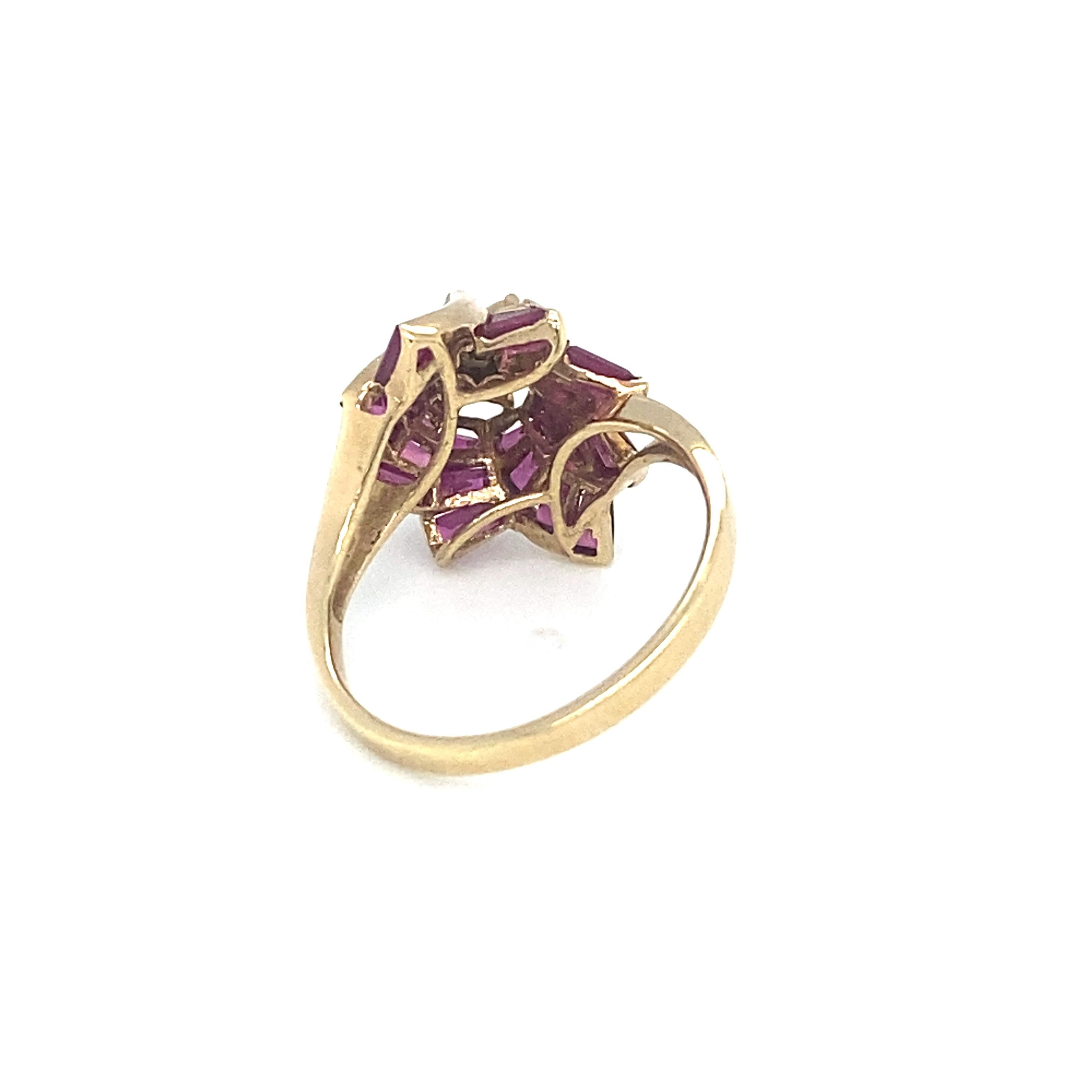 Item Details: This ring has a flower design with diamonds and baguette cut rubies.

Circa: 1980s
Metal Type: 14k yellow gold
Weight: 3.4g
Size: US 6, resizable

Diamond Details:

Carat: 0.10 carat total weight
Shape: Round
Color: G
Clarity: VS

Ruby