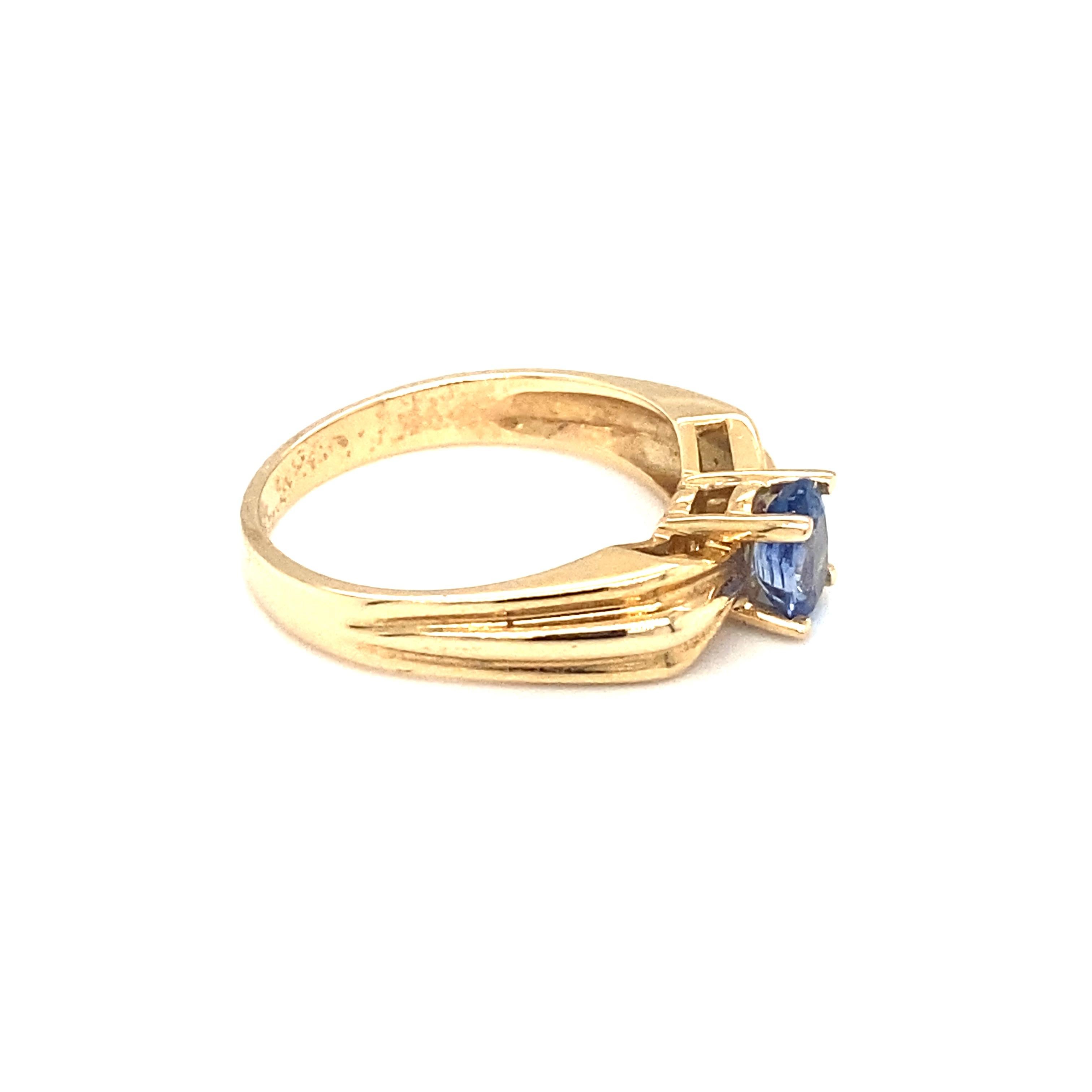 Item Details: This ring features an oval tanzanite and a ribbon design for the band and features French hallmarks.

Circa: 1990s
Metal Type: 14 Karat Yellow Gold
Weight: 3.5 grams
Size: US 7.25, resizable

Tanzanite Details:

Carat: 0.75