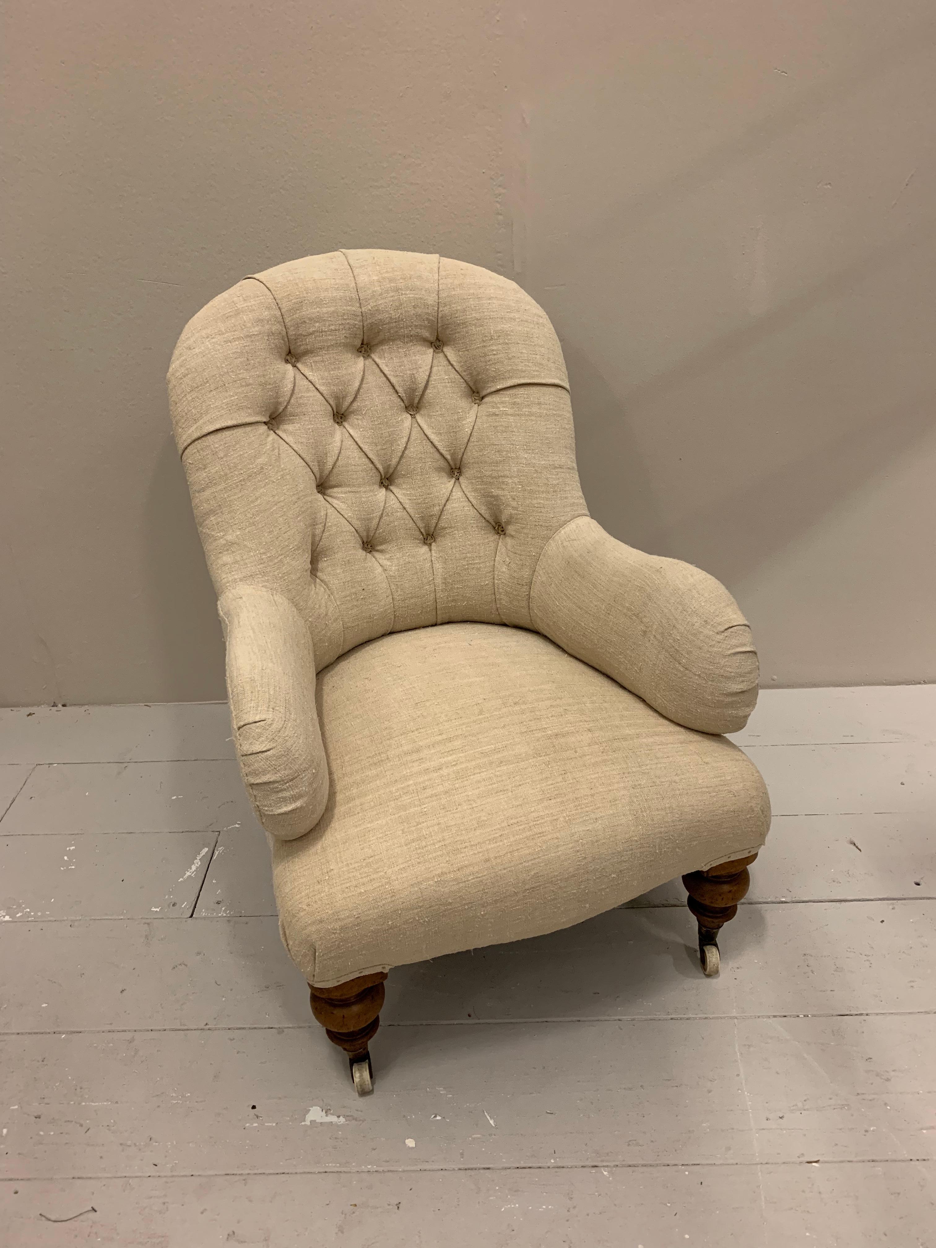 Circa 19th century upholstered English armchair with turned legs and ceramic castors.
This understated buttoned back armchair has been upholstered in a slightly coarse off white vintage french linen.
Great as a fireside, bedroom or reading chair,