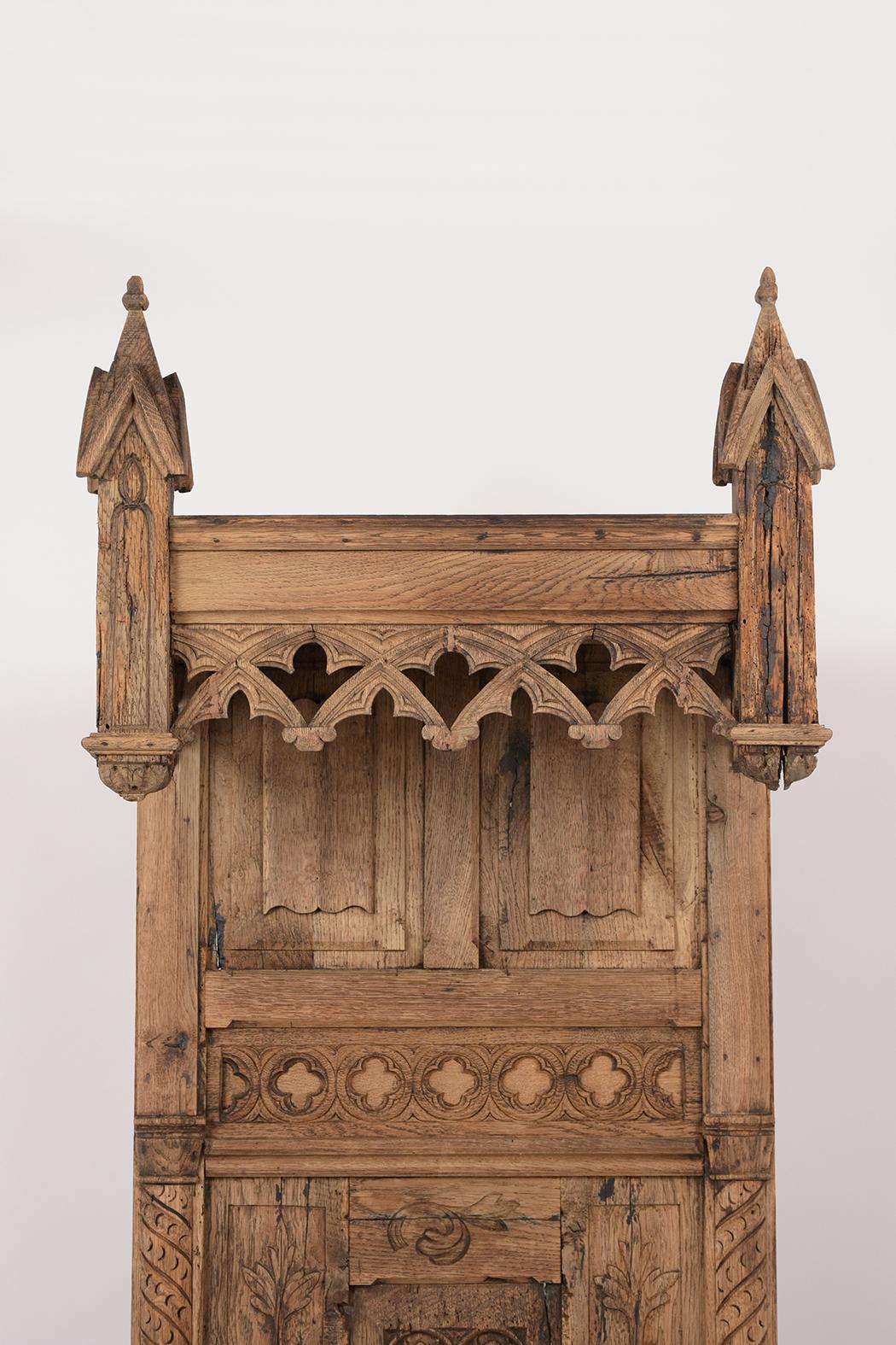 This early 19th century French throne chair is in a Gothic style, is made out of solid oakwood, and is in great condition. The chair features intricate hand carved details throughout the entire piece and a new bleached finish. The chair also has a