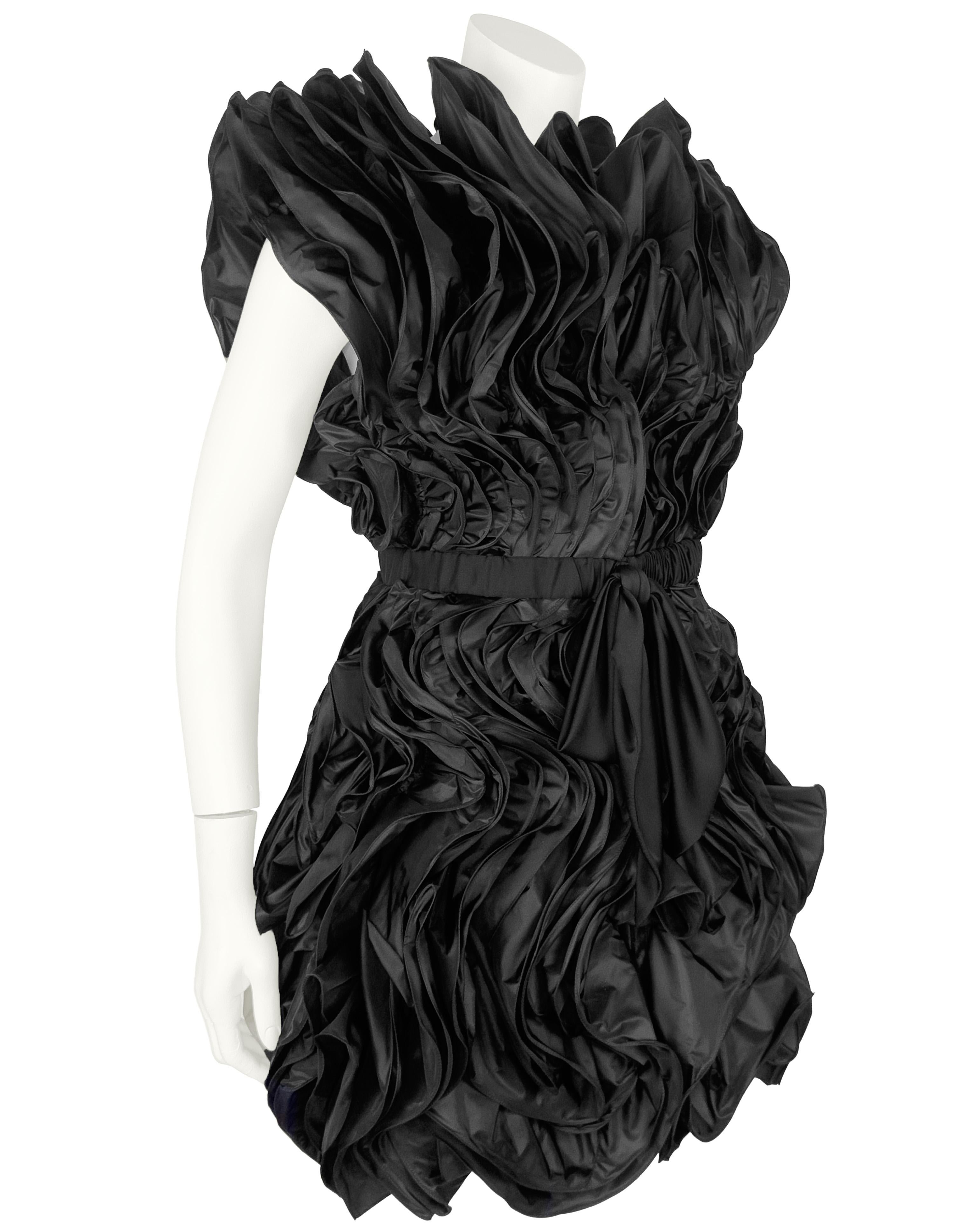 Abito con zip frontale in seta nera di Valentino. L'incredibile lavorazione ha creato un effetto architettonico a onda. Le maniche leggermente arricciate conferiscono a questo capo un tocco modernista, così come la cerniera nera sul davanti. Questo