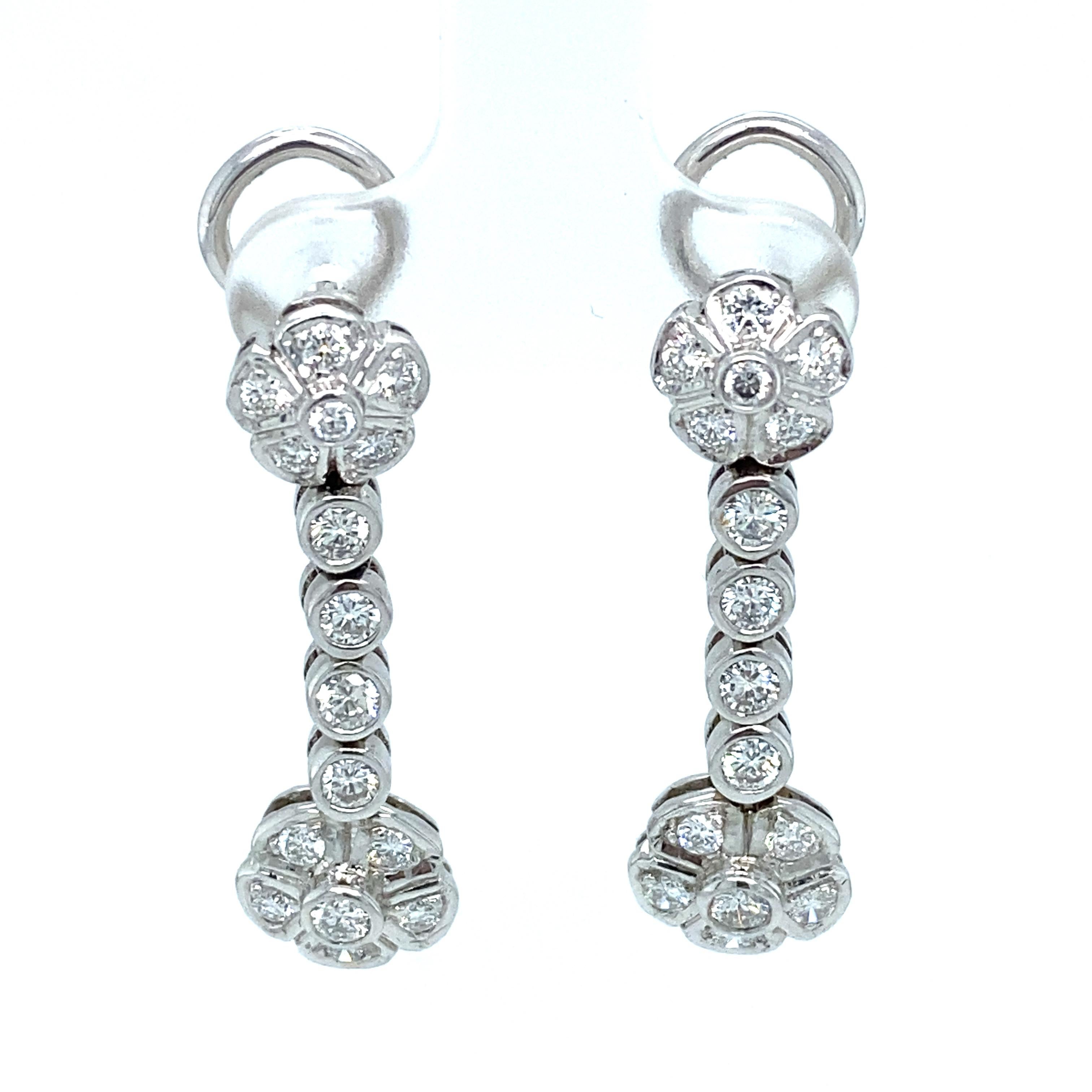 Item Details: These gorgeous diamond earrings have a dangly flower design and are backed with omega clips.

Circa: 2000s
Metal Type: 18 Karat White Gold
Weight: 7.8 grams
Size: 1 inch Length

Diamond Details:

Carat: Approximately 1.50 carat total