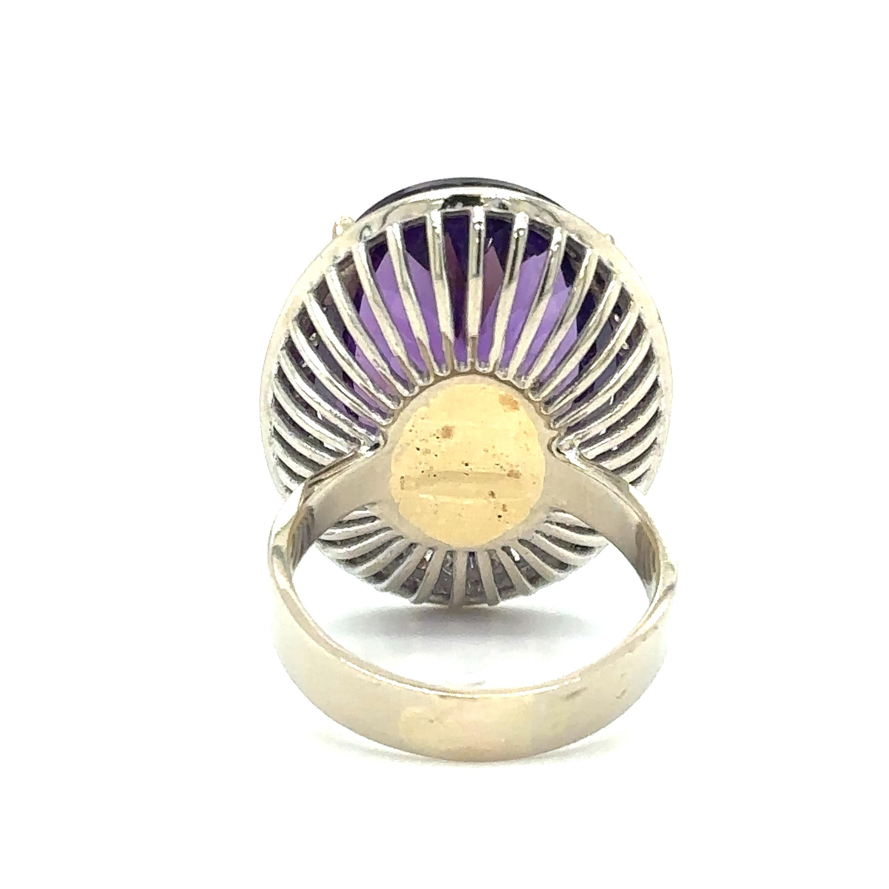 Item Details: This spectacular cocktail ring has a large, vibrant purple brilliant cut amethyst with a halo of diamonds.
The center amethyst is held by 4 talon prongs, crafted in 14 karat yellow gold. The remainder of the ring is crafted in 14 karat