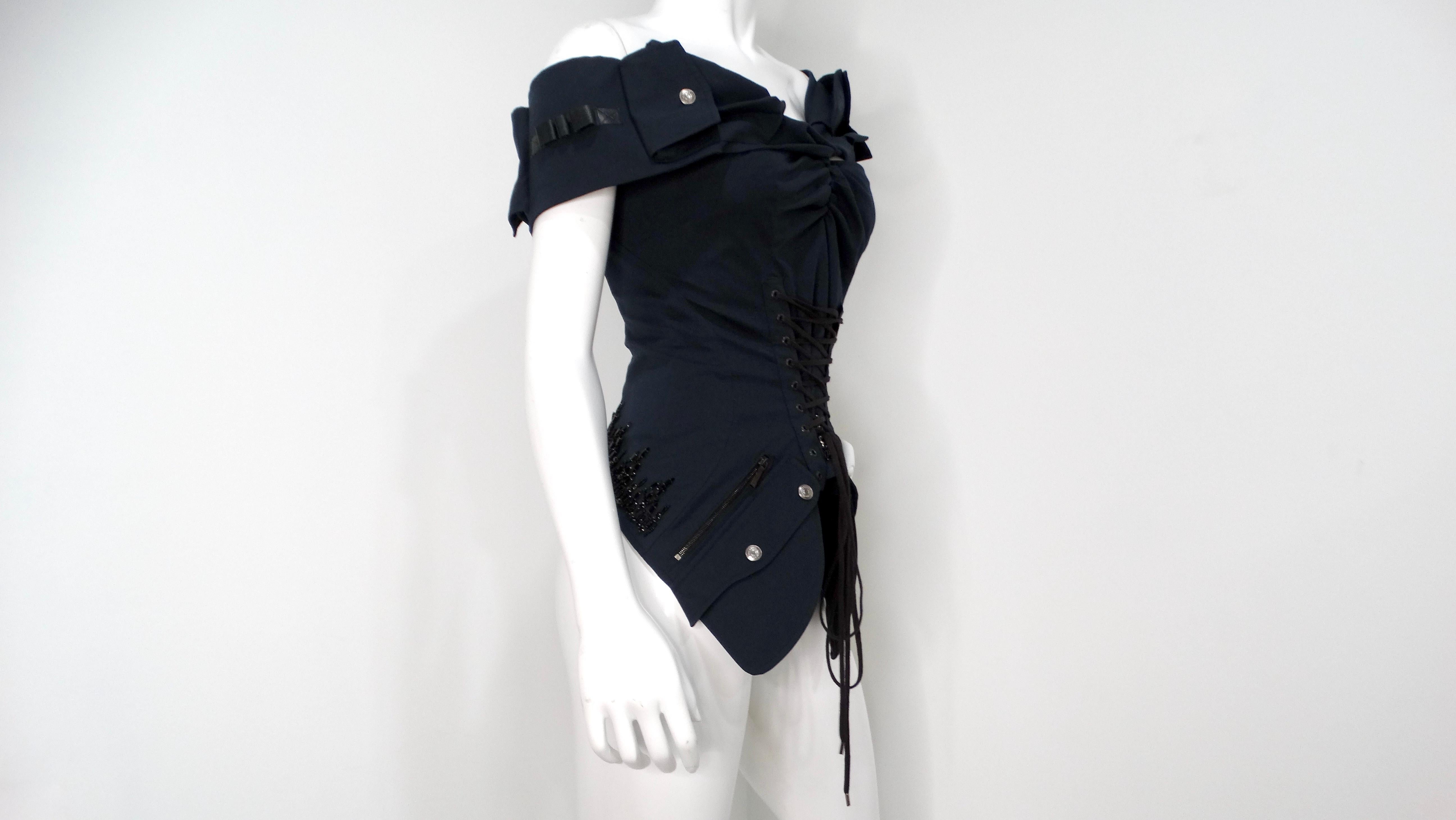This iconic circa 2003 Christian Dior Boutique corset top, a testament to John Galliano's avant-garde vision, is a striking black monochrome masterpiece. The off-the-shoulder silhouette is punctuated by a front lace-up corset detail, while intricate