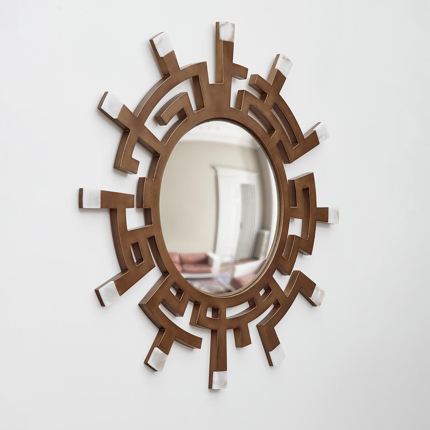 The “Circe” model is a visually striking convex mirror, showcasing a bronze frame adorned with elegant geometric patterns. At the frame's ends, meticulously set alabaster tiles provide a refined contrast to the warm bronze, highlighting the natural