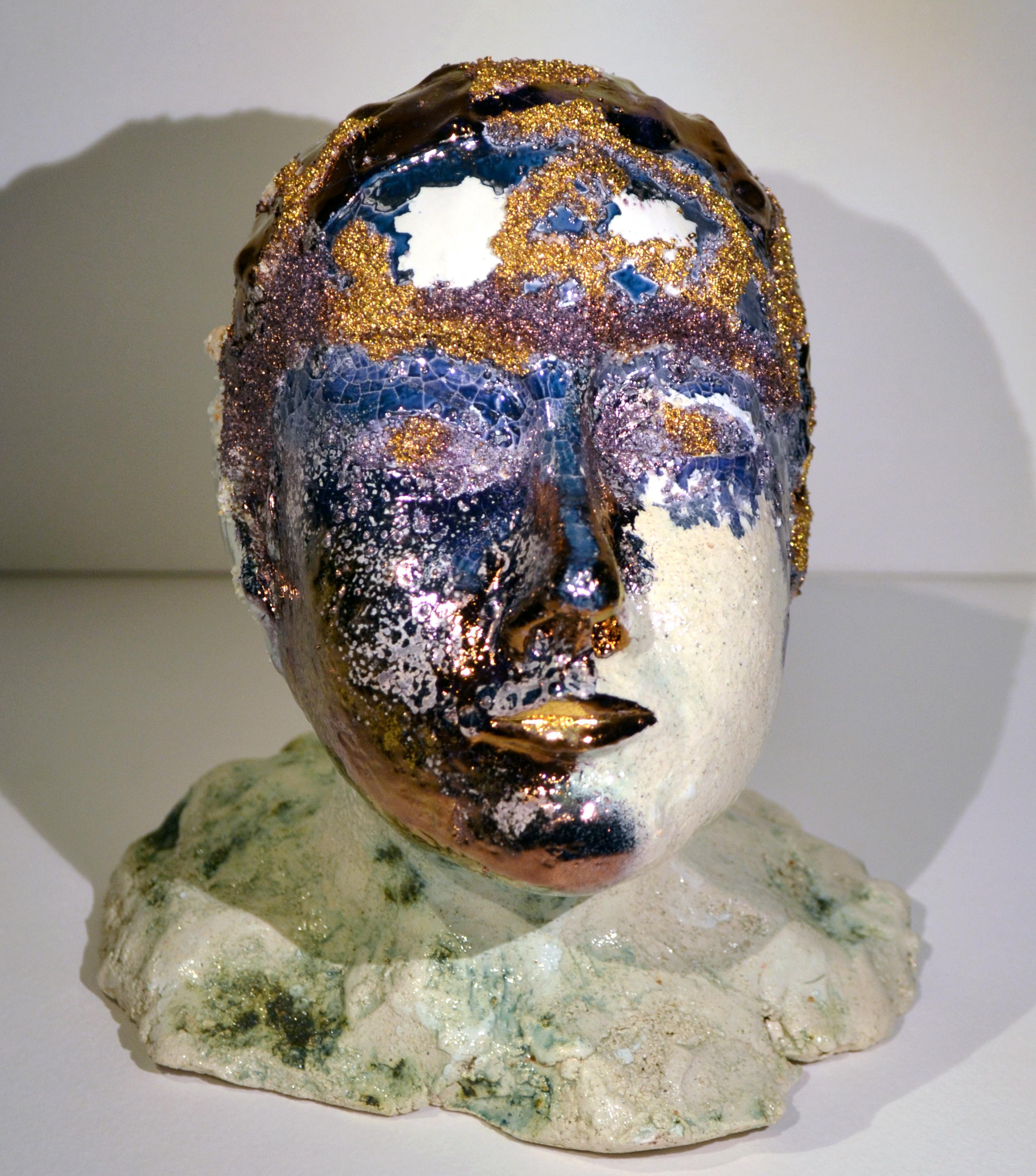 Hand-molded sculpture using a combination of white clay and raku clay with silica applications. It offers a modern interpretation of the classical bust embellished with blue, copper, and purple lustre decoration, accented by copper and 24k gold