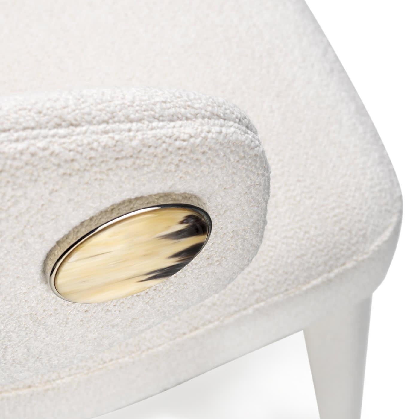 Chair upholstered in bouclé fabric, white color with detail in horn and chromed brass. Feet in chromed brass. Please, contact the Concierge for further information. 