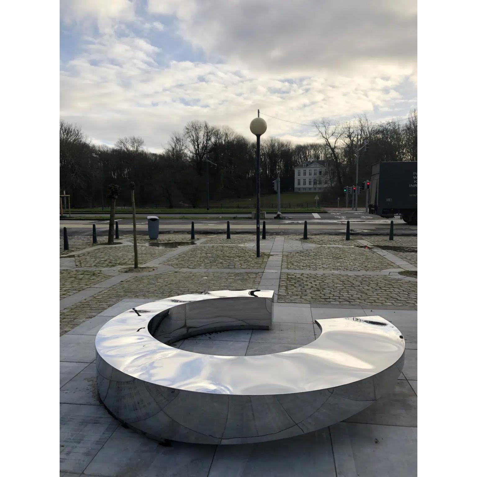 Panchina Circle di Pol Quadens 
Un pezzo unico.
Dimensioni: D 45 x L 45 x H 300 cm.
Materiali: Acciaio inossidabile lucidato.

Pol Quadens è nato a Bruxelles. Suo padre era attivo nel campo dei compositi e dell'industria metallurgica e il mondo dei