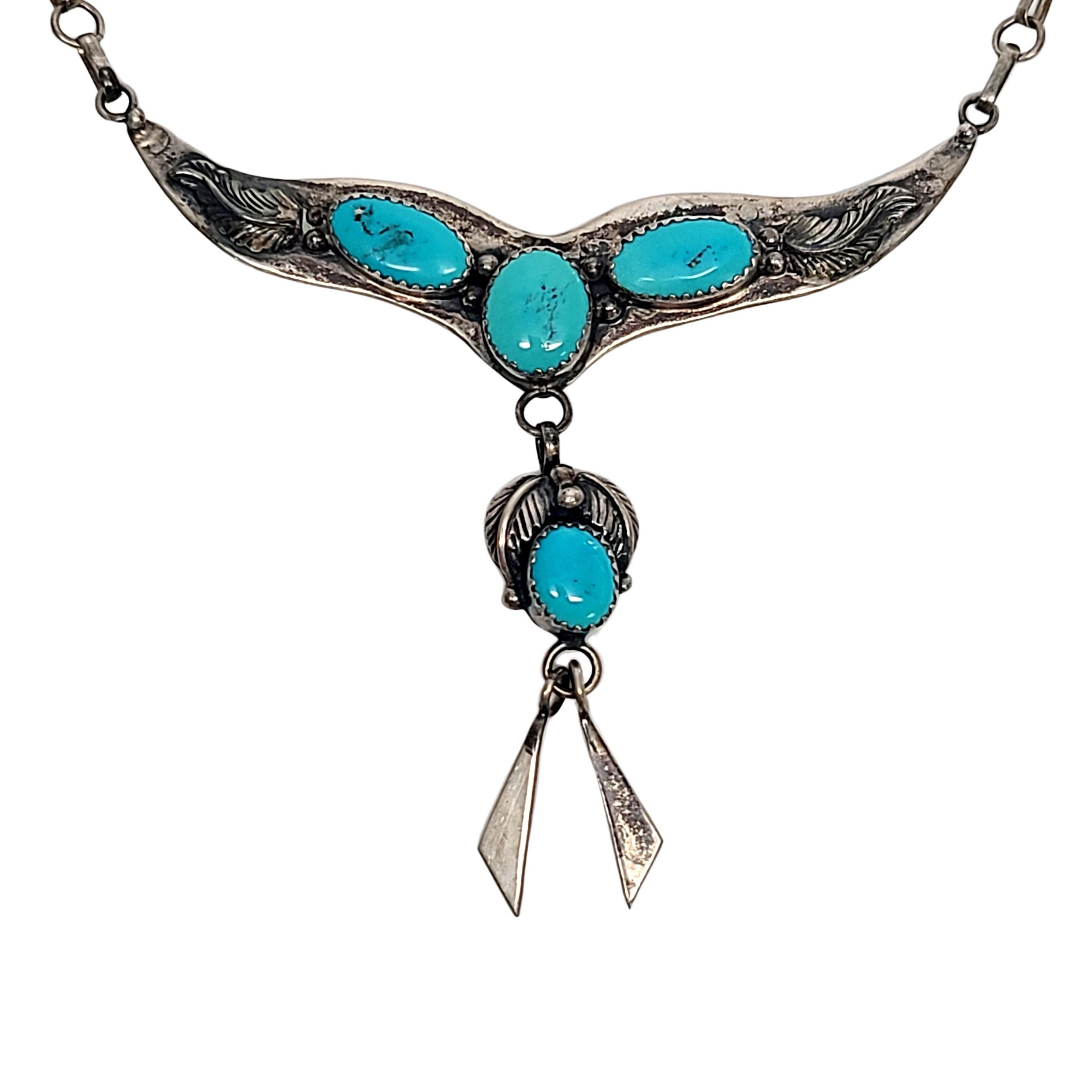 Sterling silver and turquoise necklace by Native American artisan Jack Whittacker.

Beautiful necklace featuring a drop pendant, feather details and saw tooth bezel set turquoise stones.

Measures approx 18  1/2