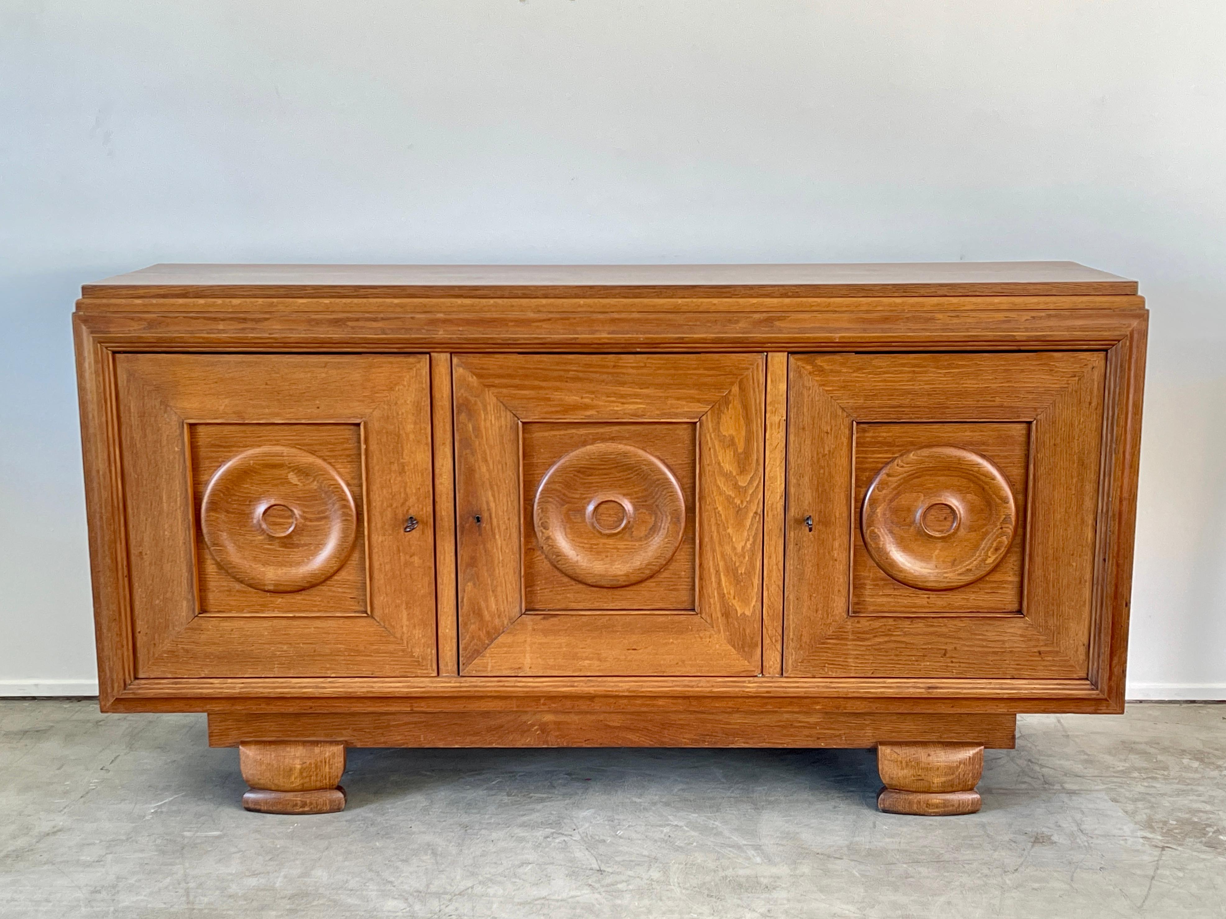 1940's French Oak cabinet with carved concentric circles on the 3 front doors.
Wonderful carved legs and warm patina to wood!
