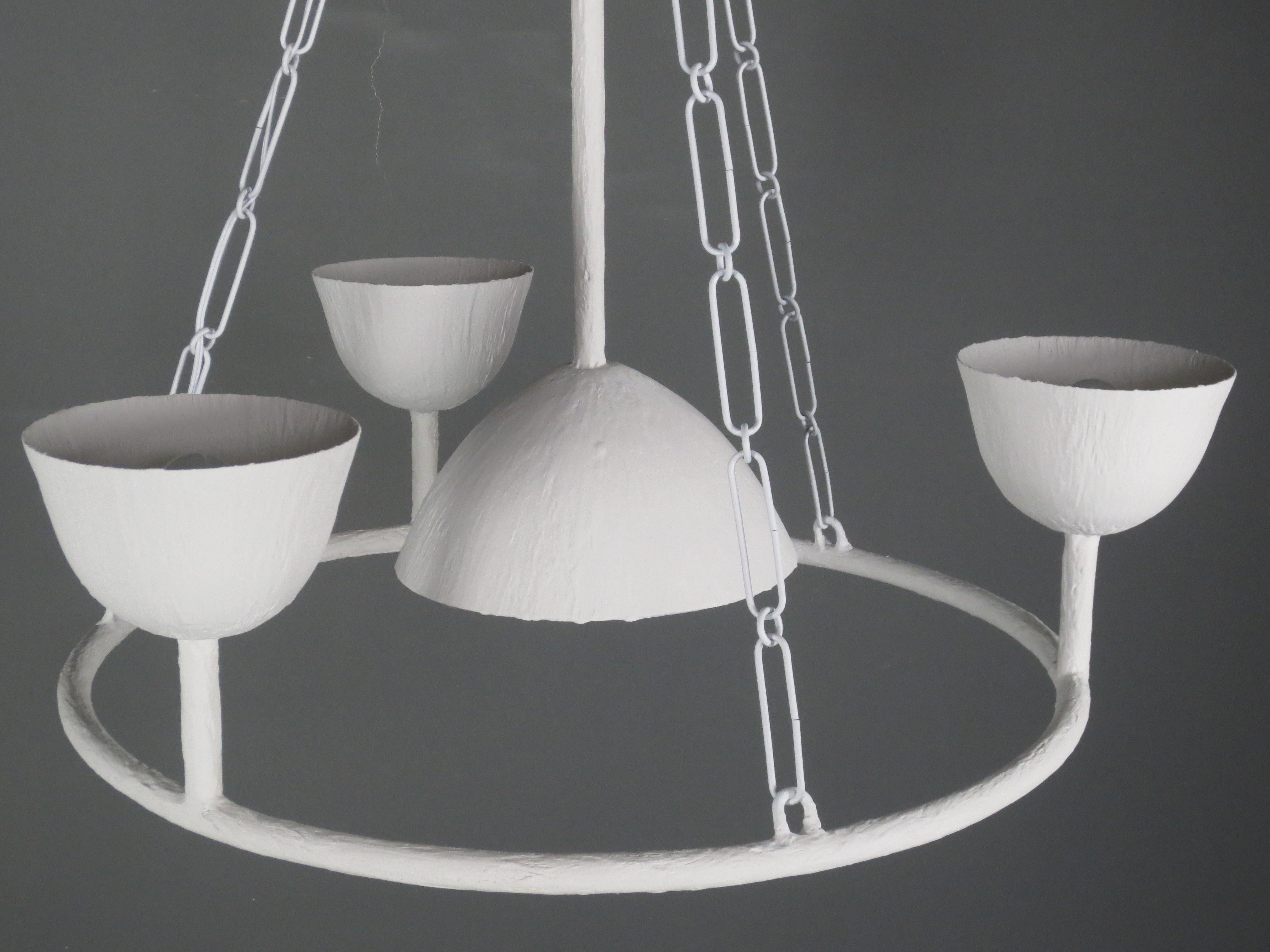 Circle of 4 Cups Plaster Chandelier by Tracey Garet of Apsara Interior Design.
Elegant Circle of 4 cups with each cup containing a candelabra light.  Three of the cups face up with a central cup facing down through the circle. The chandelier can