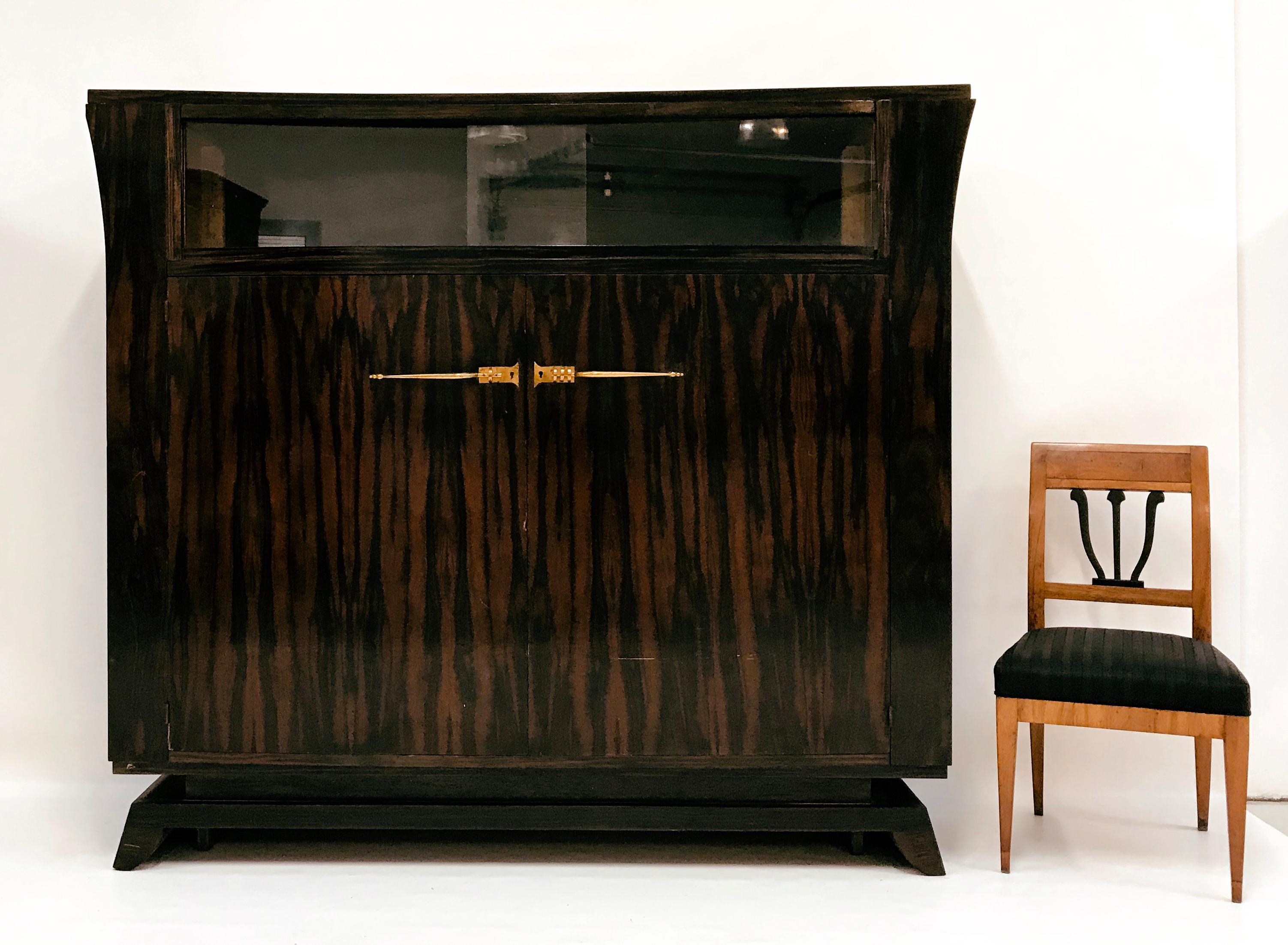 Circle of / Follower of Jacques-Emile Ruhlmann - Art Deco sideboard, 1920s. Made of rosewood. 

Tapered pedestal, above two-door furniture corpus. No ornamentation is used at all; instead, the very fine rosewood veneer and the modern basic shape,