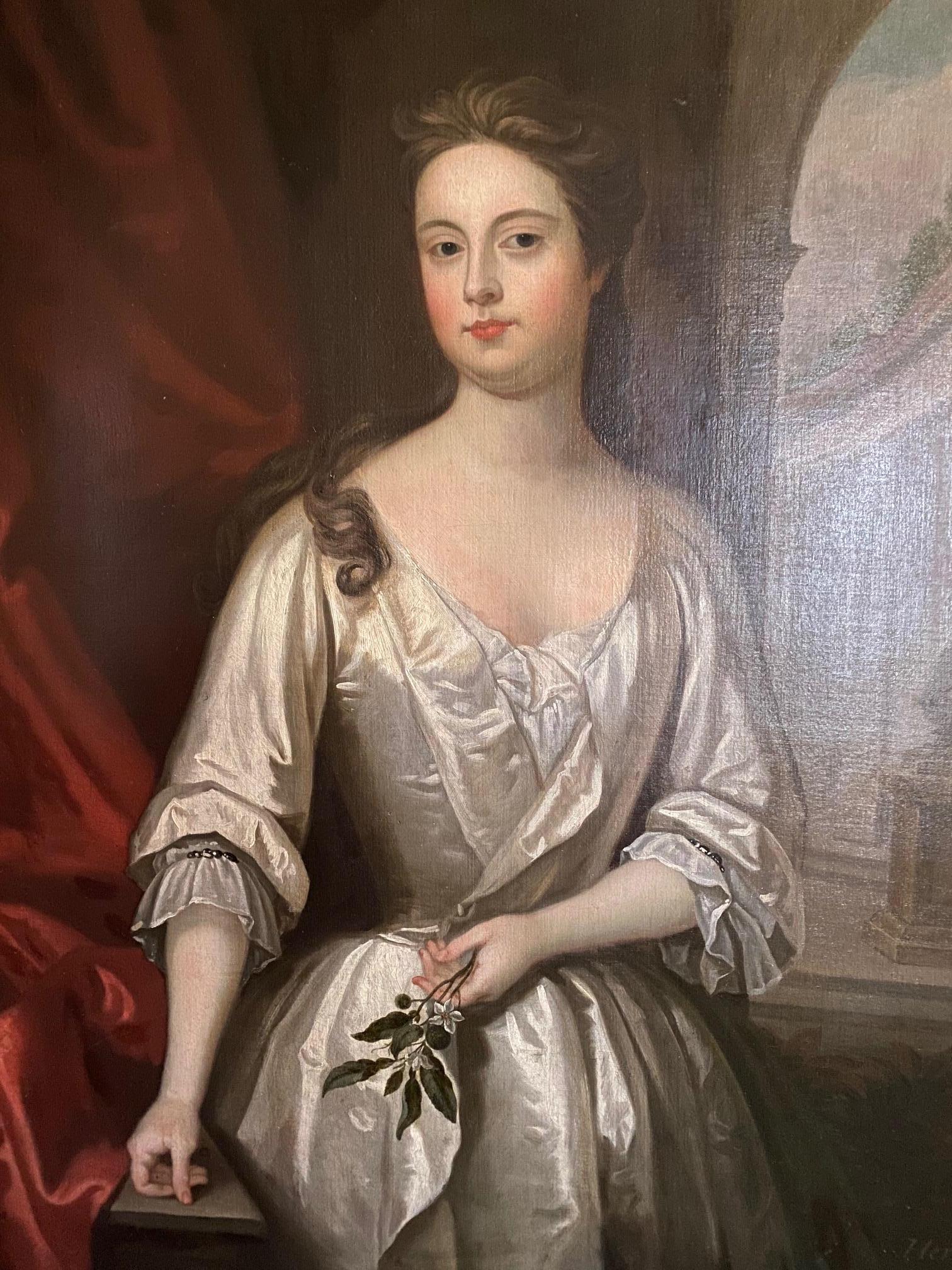 Oil-on-canvas portrait of Lady Henrietta Crofts, Duchess of Bolton and daughter of the Duke of Monmouth, standing three-quarter length in white silk dress holding orange blossoms with classical landscape in the background by Circle of Sir Godfrey