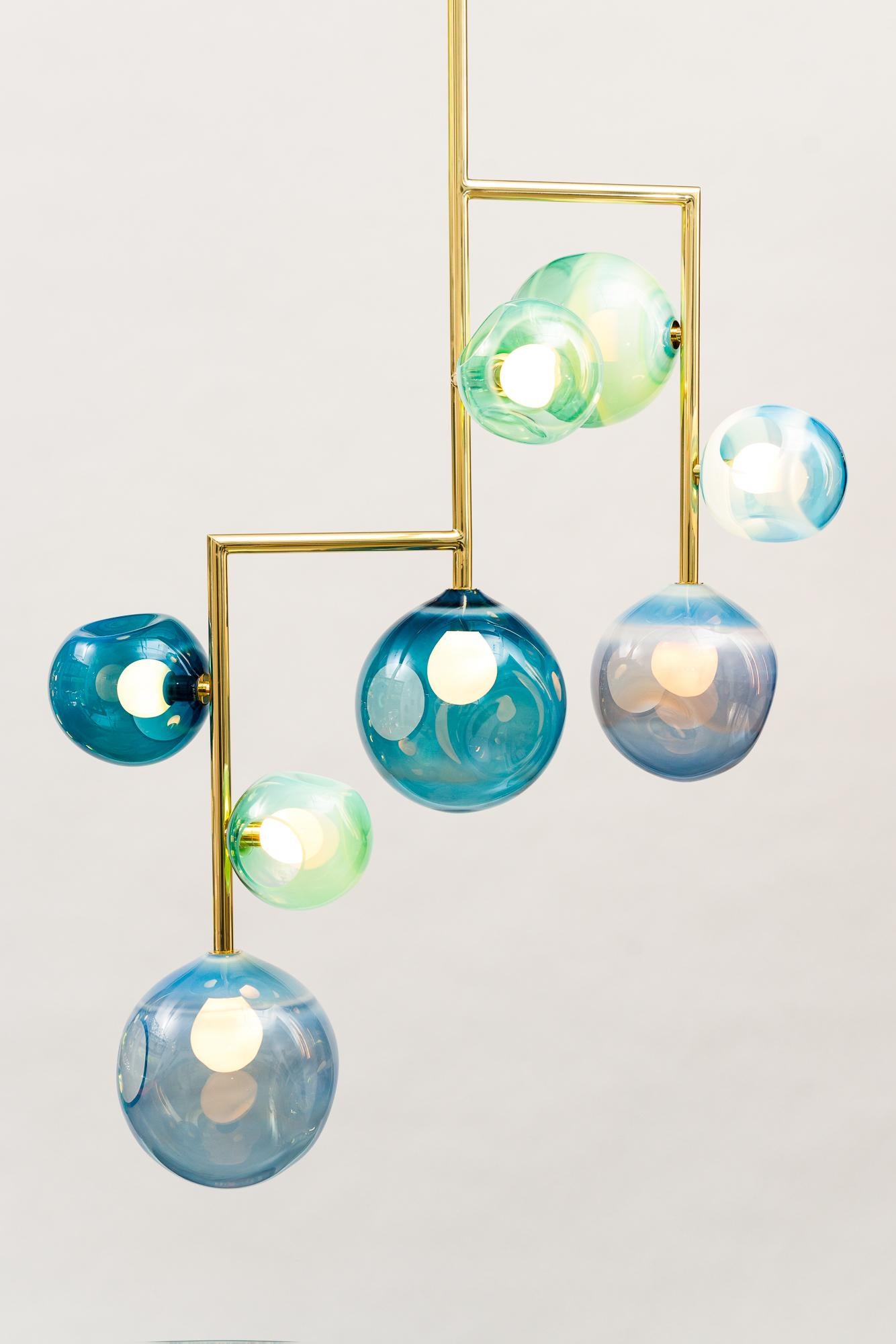 Today in addition to his fine art glass sculptures, Jamie Harris is creating unique, hand-made sculptural lighting. Drawing on the contrast between rigid, geometric metal structures and organic, hand-made glass forms, his chandeliers achieve a