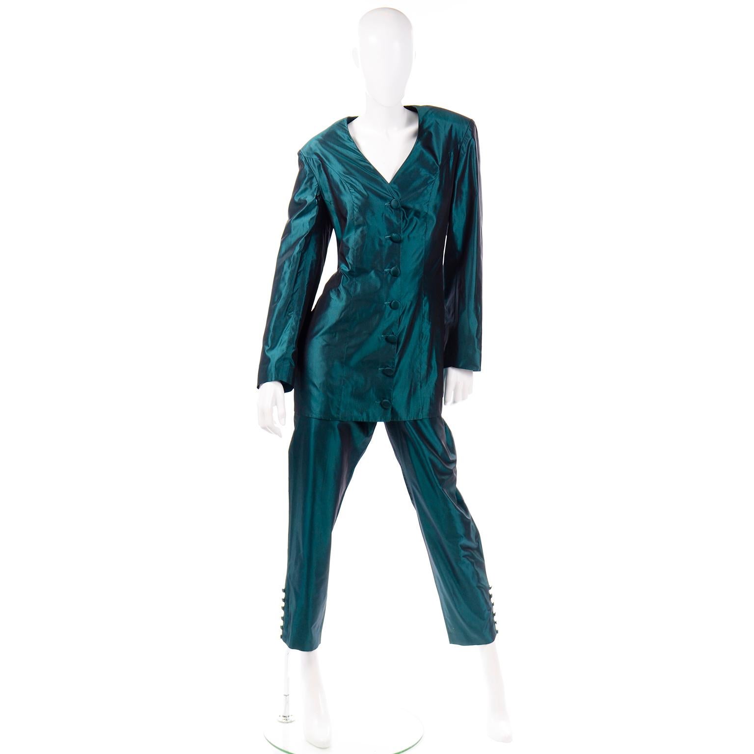 This vintage 2 piece evening pantsuit is in a luxurious green silk taffeta. This suit has a long line jacket, with a deep v-neck, and covered buttons down the center front opening. The waist of the blazer has darts, which help accentuate and shape