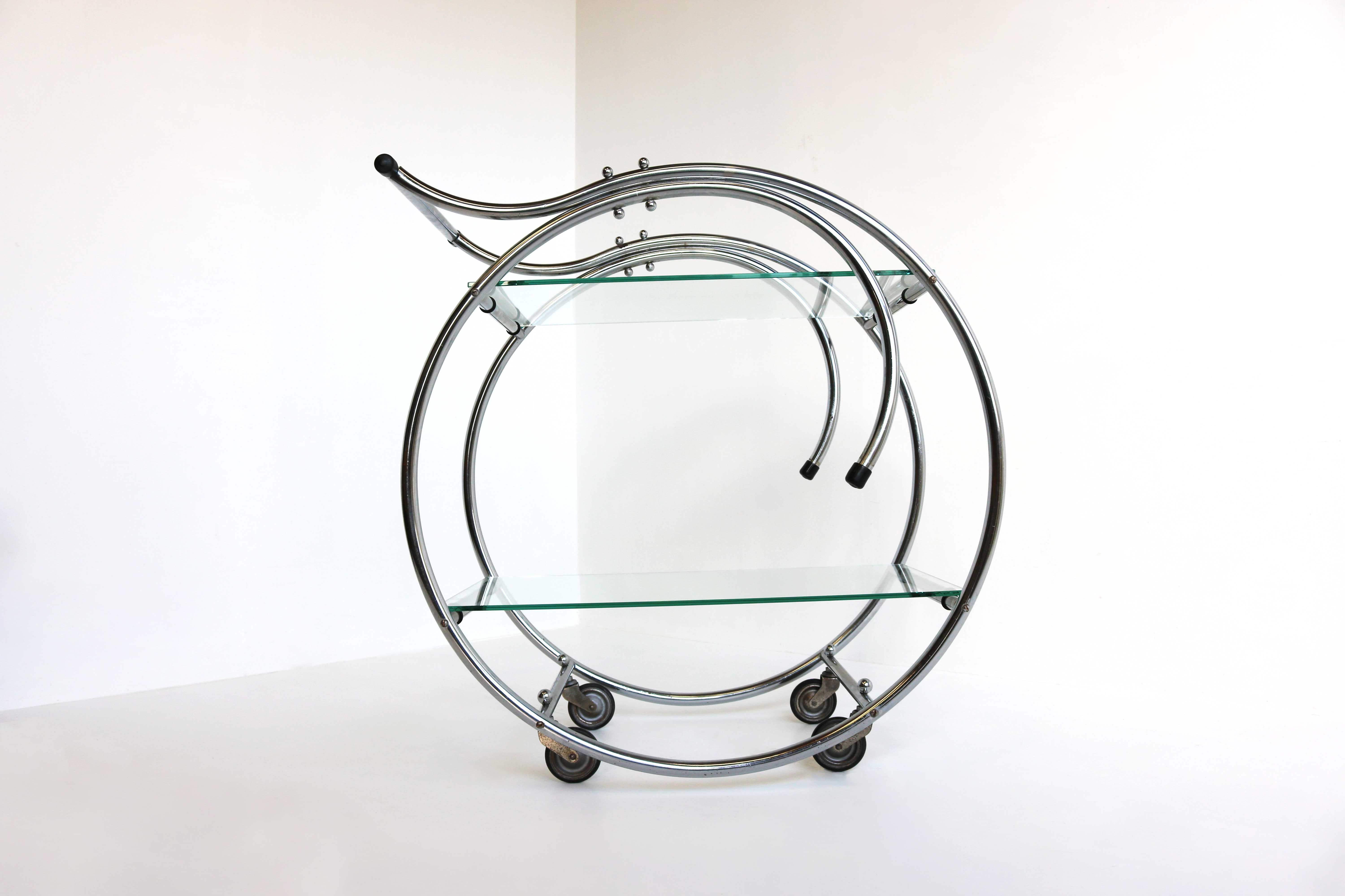 Circular Shape Authentic Art Deco Bauhaus bar cart in chrome & glass from the 1930s. 
Gorgeous Art Deco design with timeless chrome bends & two tiers of glass. Marvelous antique piece that will make a lasting impression. Will fit in almost any
