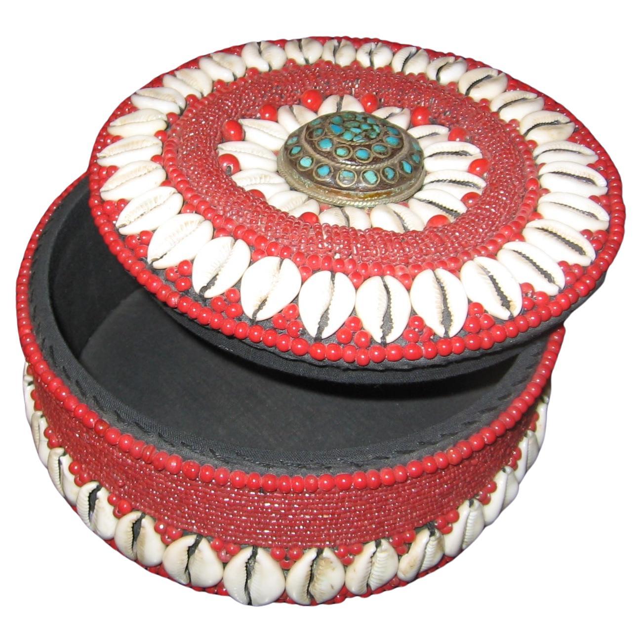 Caja circular de cuentas y conchas con pomo decorativo de latón