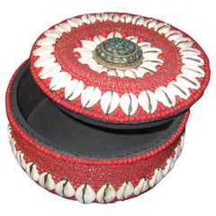 Caja circular de cuentas y conchas con pomo decorativo de latón
