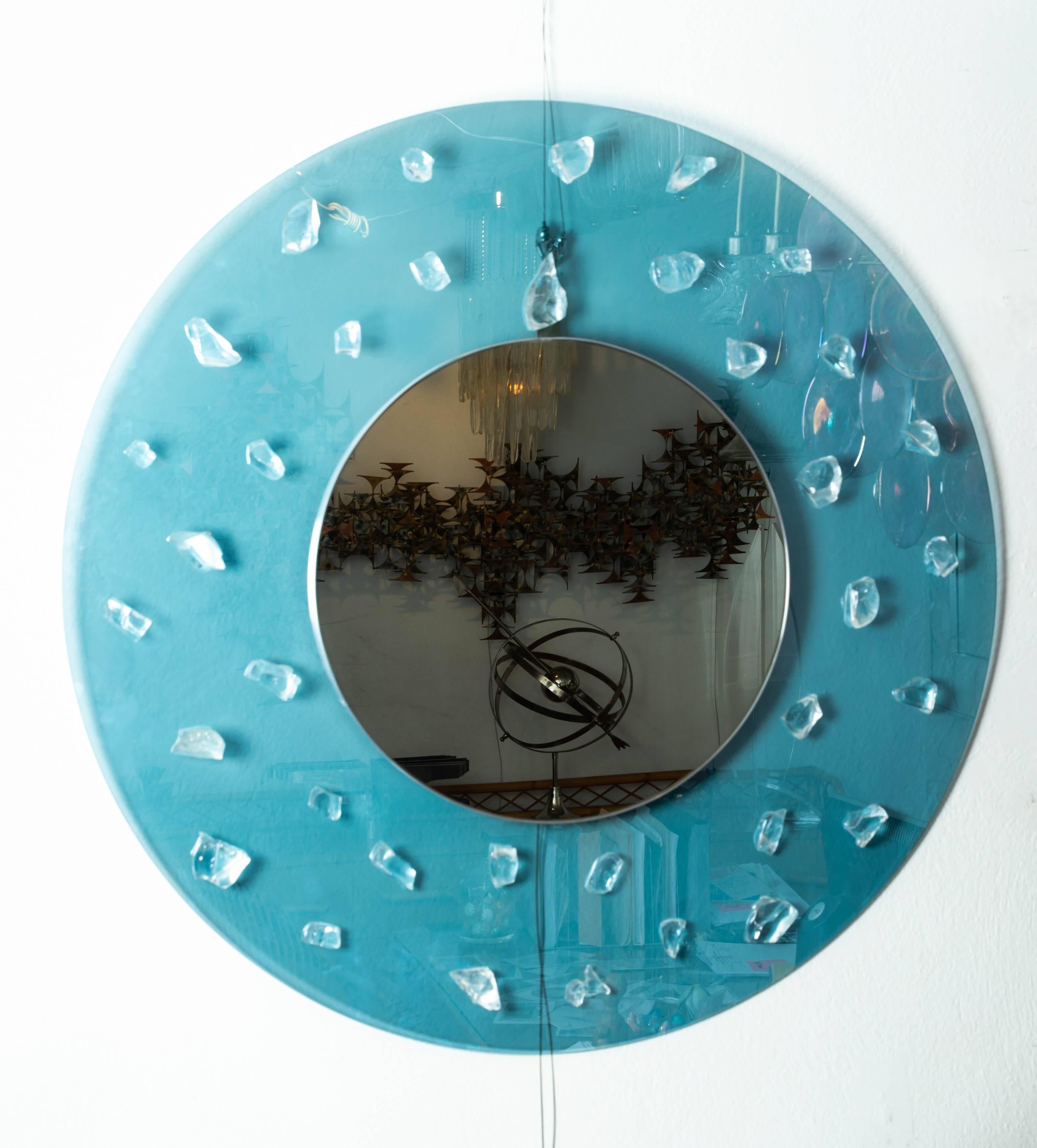 Circular blue glass surround mirror with applied glass fragments.