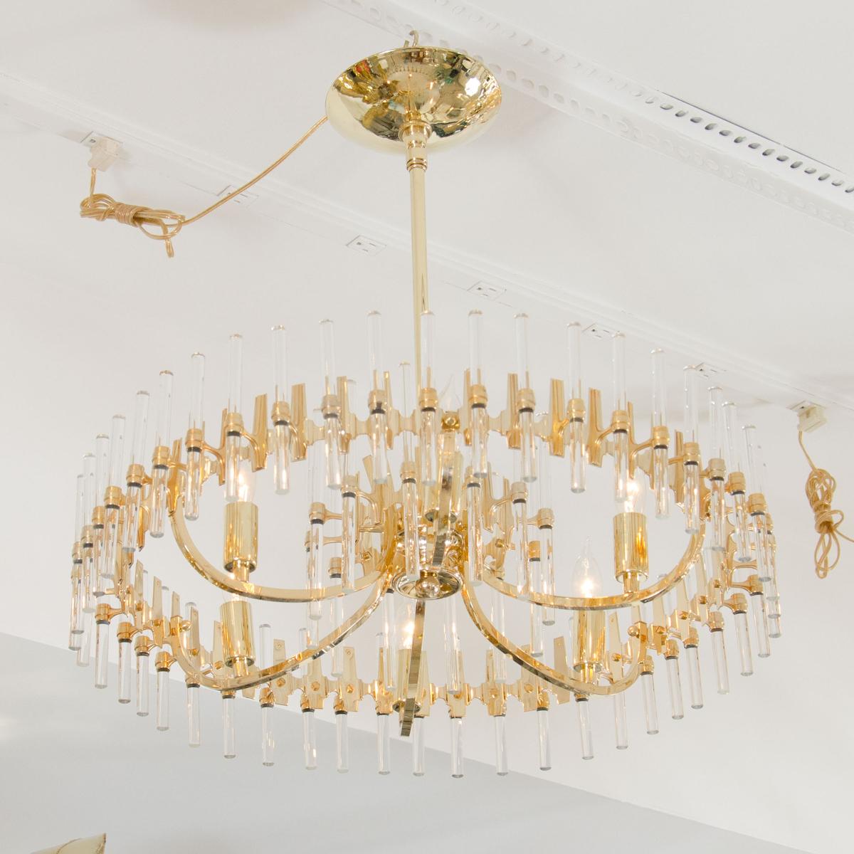 Circular brass six-arm chandelier with tubular glass decoration.